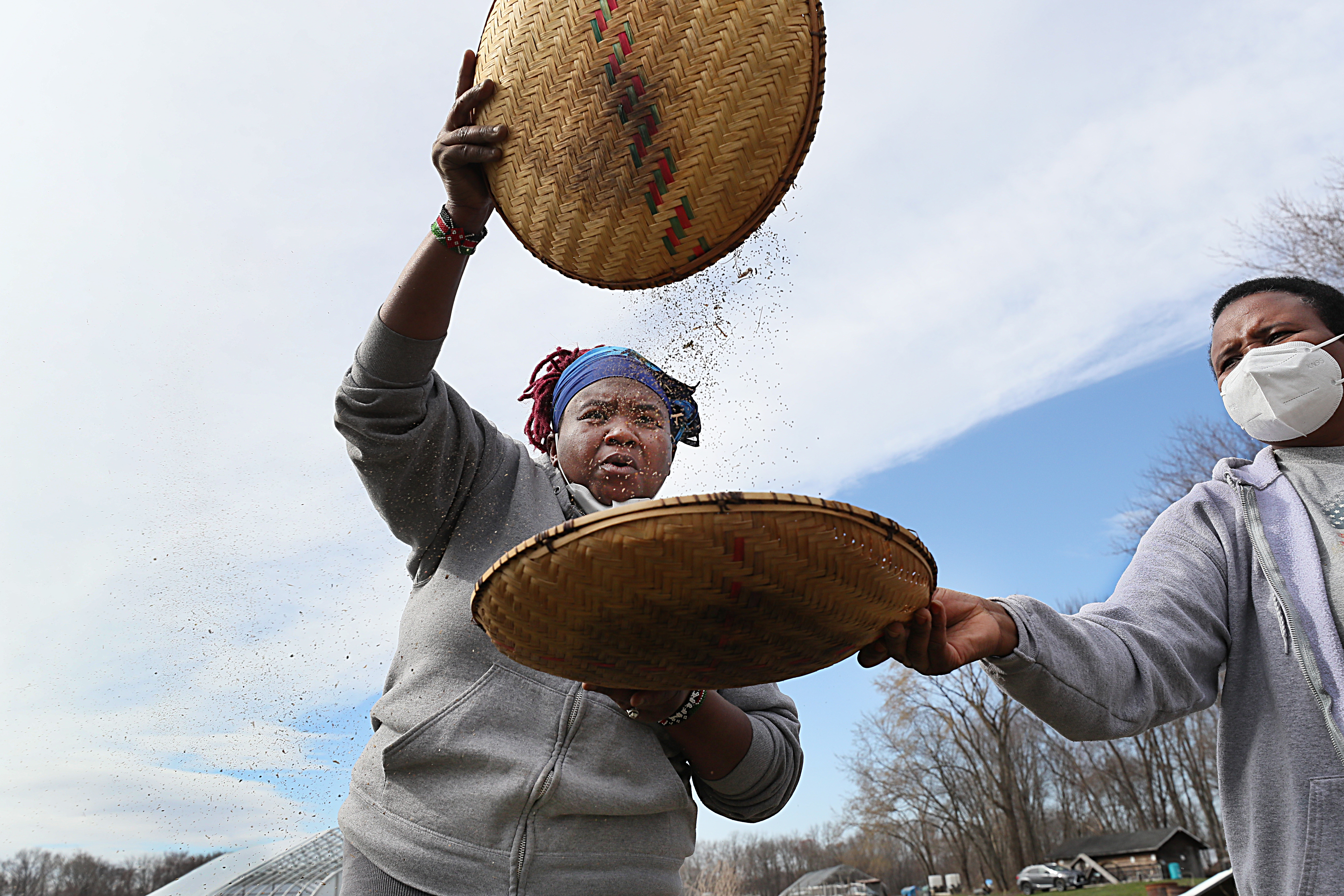 Henrietta Nyaigoti with her mother, Veronicah Nyaigoti (right), working with baskets of chinsaga spider plant seeds.
