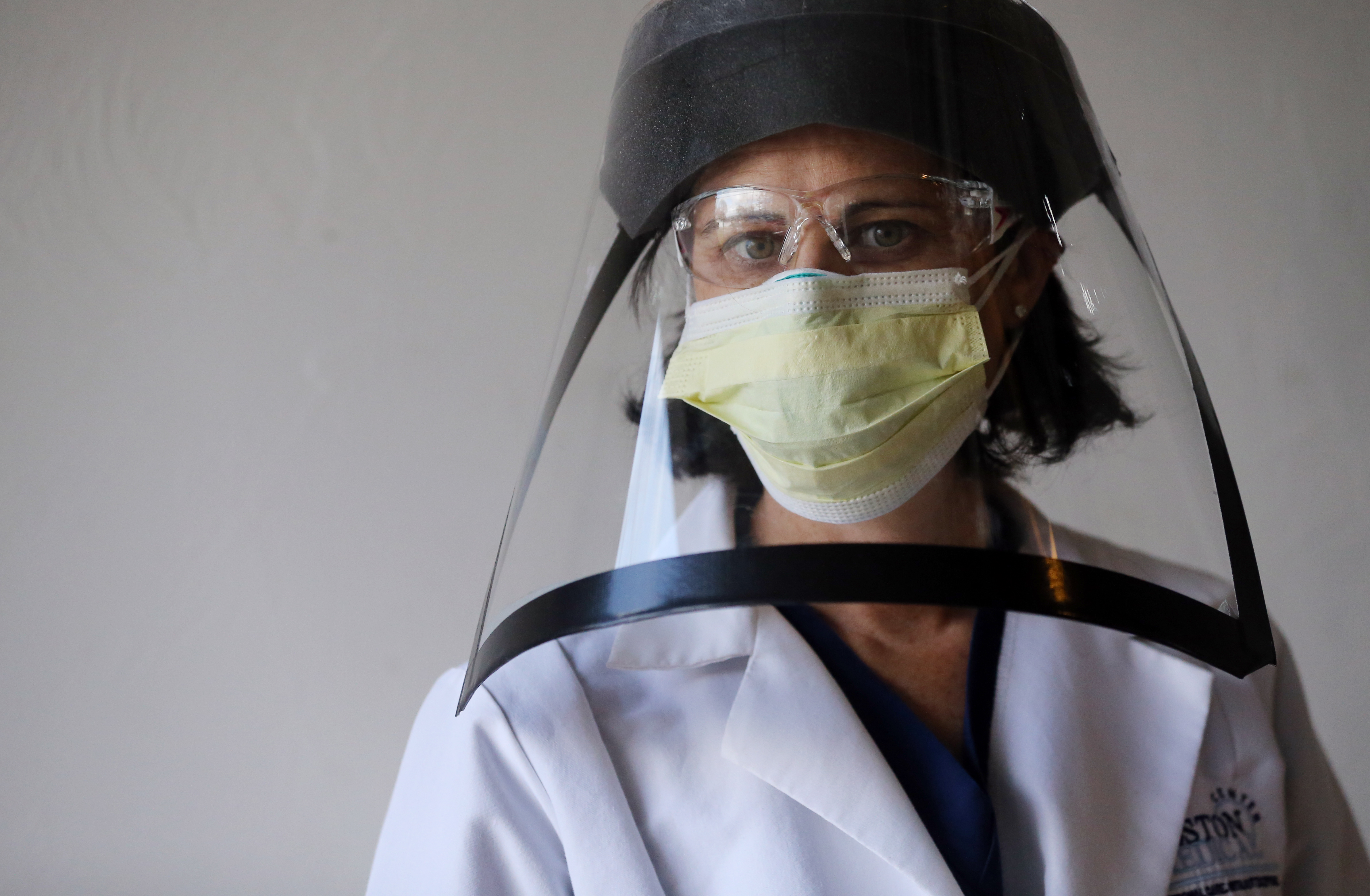 Milton,MA - 3/24/2020: Dr. Elissa Perkins poses for portrait with protective equipment, including a reusable face shield her husband constructed from household items at their home in Milton, MA on March 24, 2020. (Dr. Elissa Perkins, an emergency medicine at Boston Medical Center, and on the fears of working on the frontlines of the coronavirus pandemic without adequate PPE, or personal protective equipment, to keep her and her colleagues from getting sick.) (Craig F. Walker/Globe Staff)