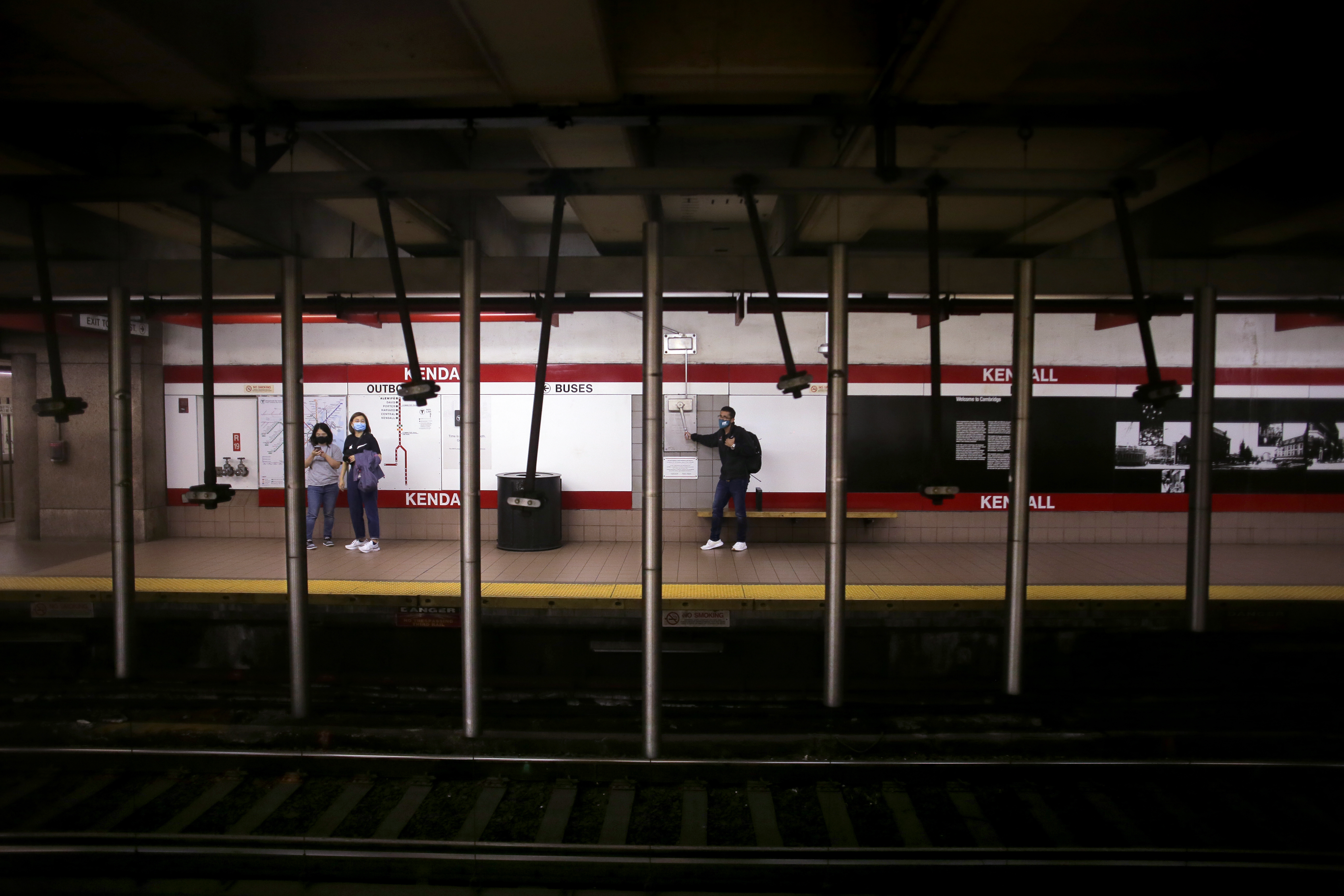 A passenger pulls a lever of “Kendall Band," a musical sculpture at the Kendall/MIT station.