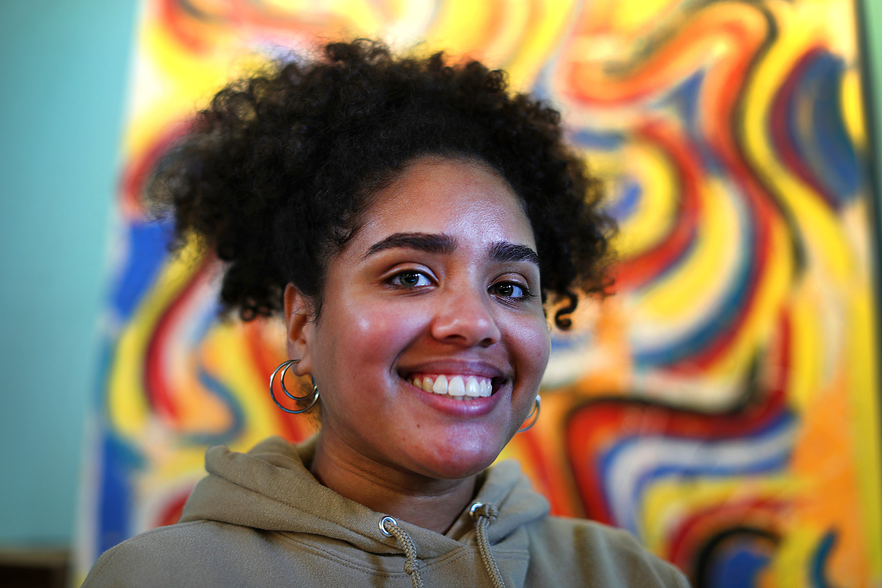Celeste Cruz, 22, who works for a Lawrence nonprofit, posed in front of a work of art at El Taller, a popular hangout in the city's downtown.