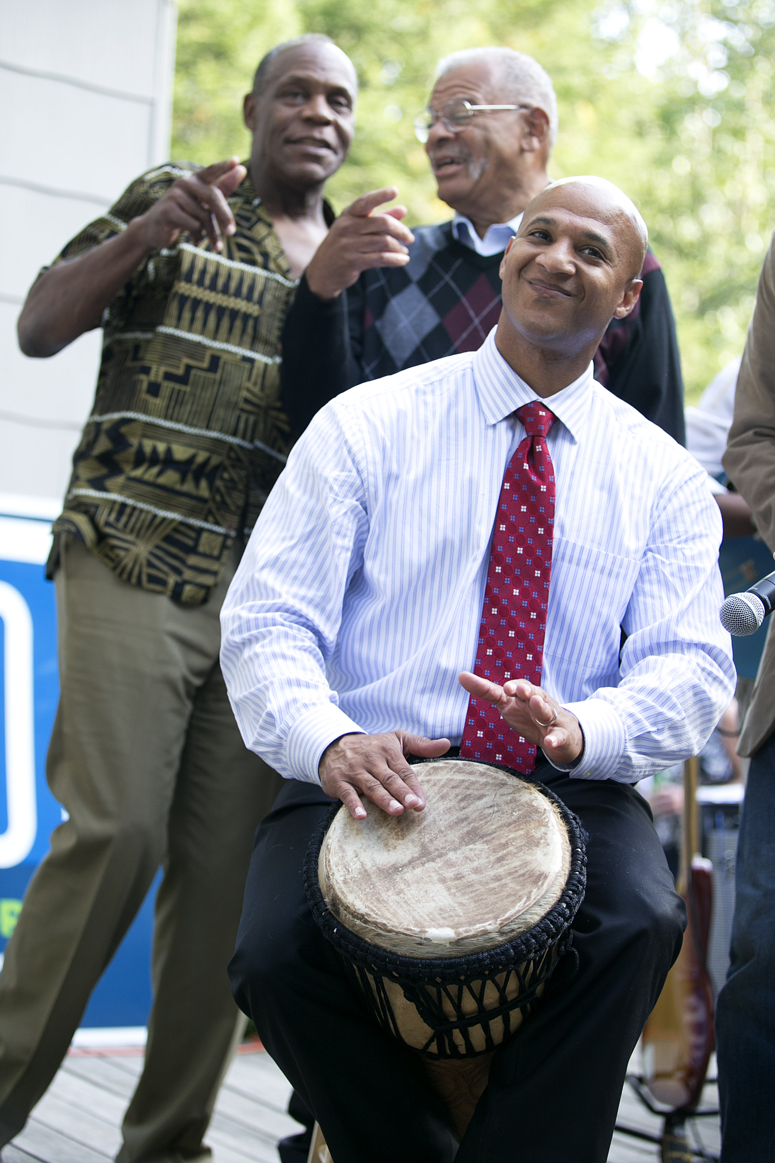 John Barros played the drum while actor Danny Glover, left rear, and former Dudley Street Neighborhood Initiative executive director Gus Newport stood on stage behind him during Barros's 40th birthday celebration on Sept. 15, 2013, in Jamaica Plain.