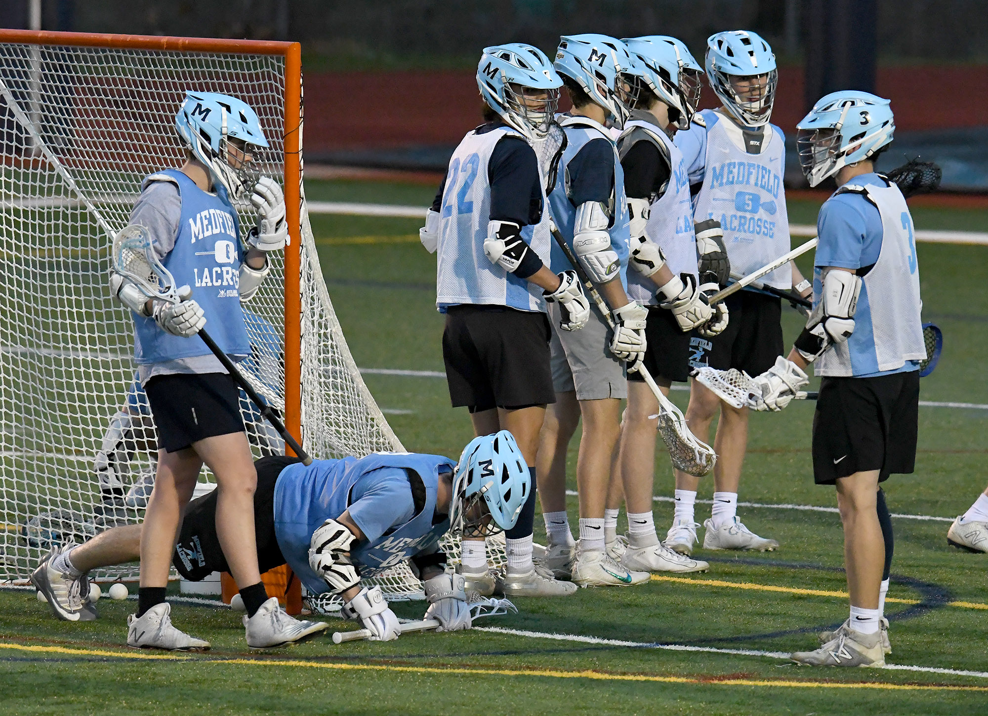 The Medfield boys' lacrosse team was back at work at practice Wednesday night, including one player tasked with a few pushups after a drill.