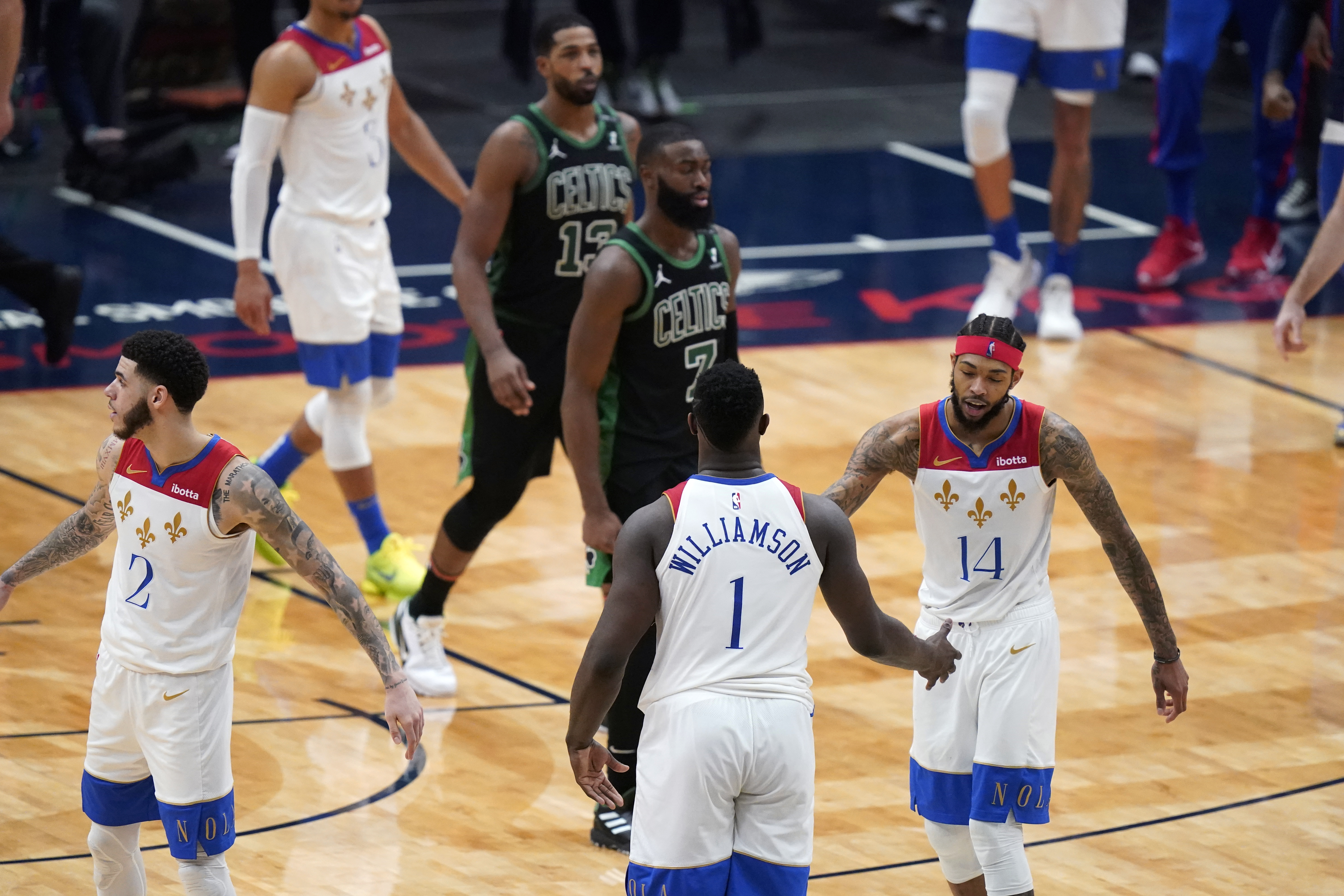 Zion Williamson celebrates with Brandon Ingram and guard Lonzo Ball in the second half of Sunday's game.