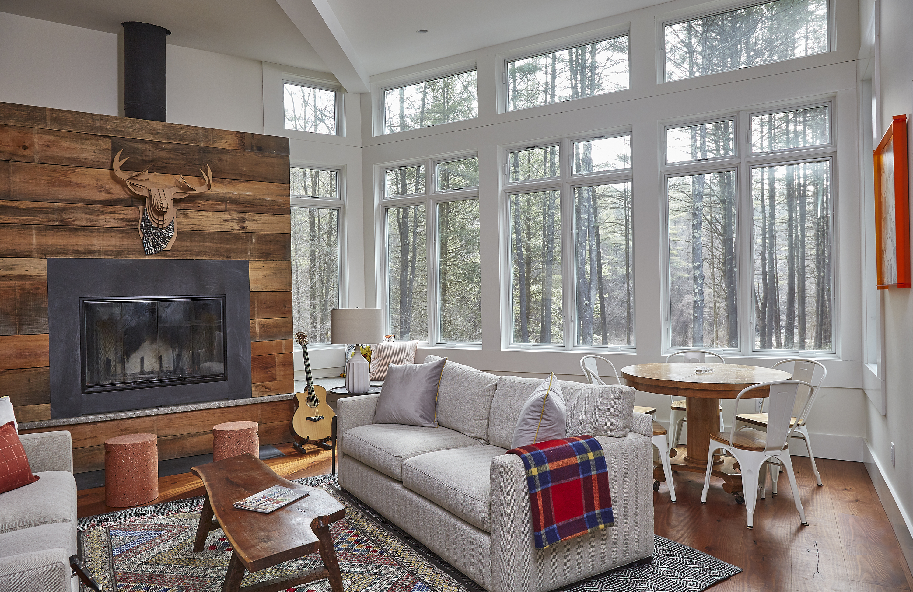 The fireplace wall has a concrete ledge that turns into a bench when it wraps the corner. The live edge coffee table came from Suriel’s personal stash and she found the rust-colored stools at HomeGoods.