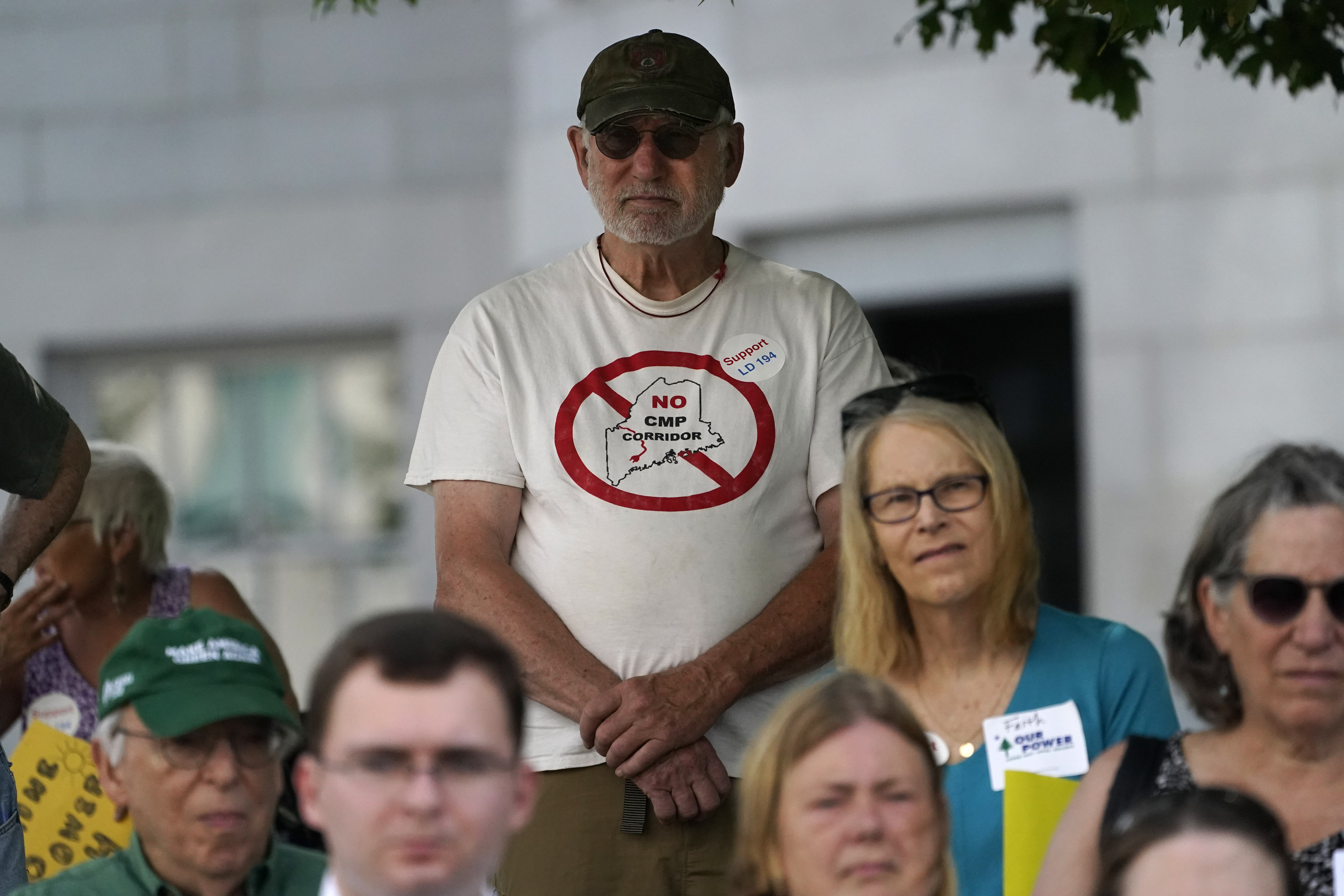 Protesters attended a news conference to show their support for overriding Governor Janet Mills's veto of a bill that would have banned entities owned by foreign governments from influencing Maine elections. The bill was inspired by Hydro-Quebec's vast spending to persuade Maine voters to defeat a referendum that would sink Central Maine Power's transmission project.