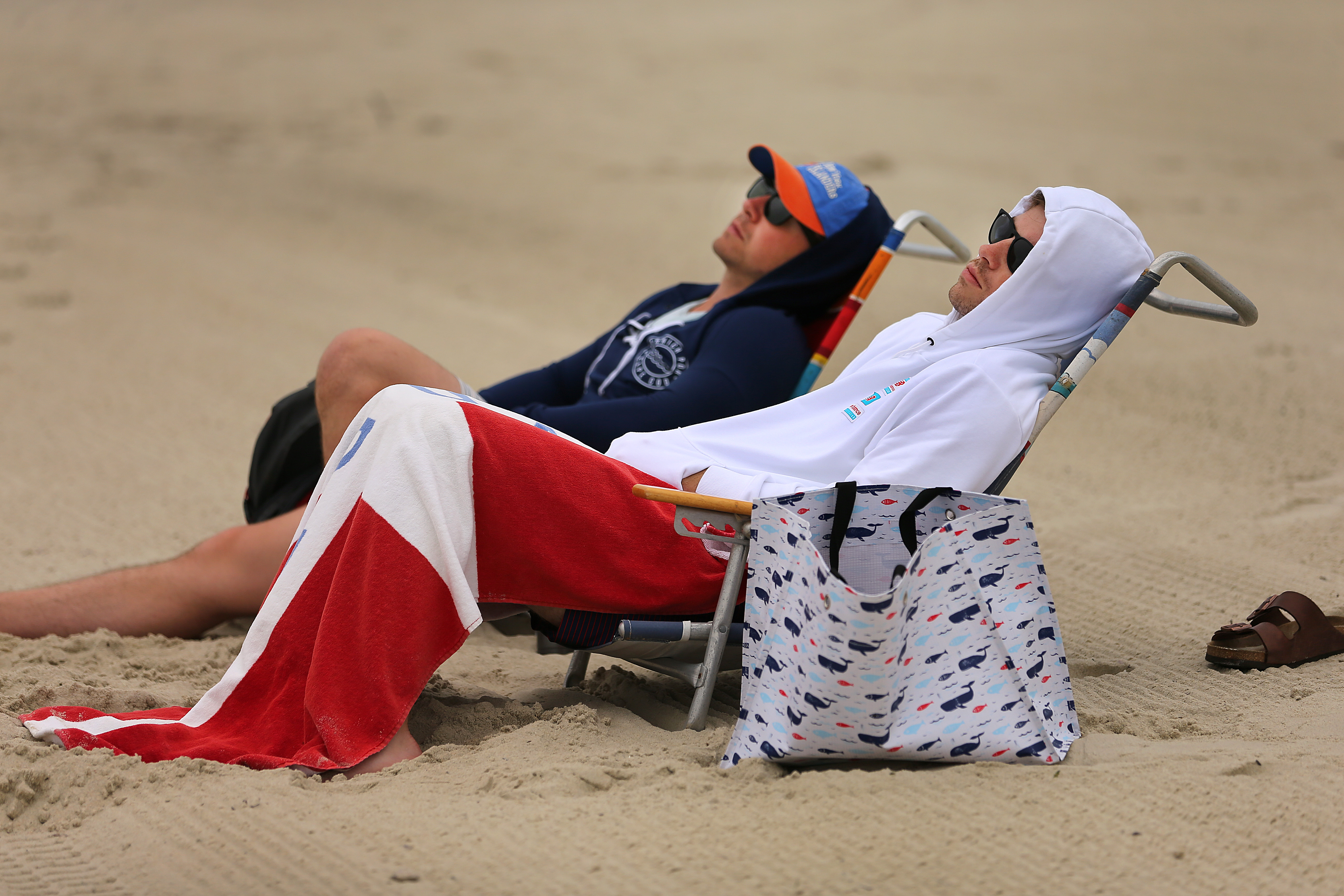 Sean Cosentino (left) from Westchester, N.Y., and his cousin Caleb Callaway from Nashville stayed warm as they took a nap on Bank Street Beach. “It’s a bummer that the sun isn’t out,” Cosentino said.