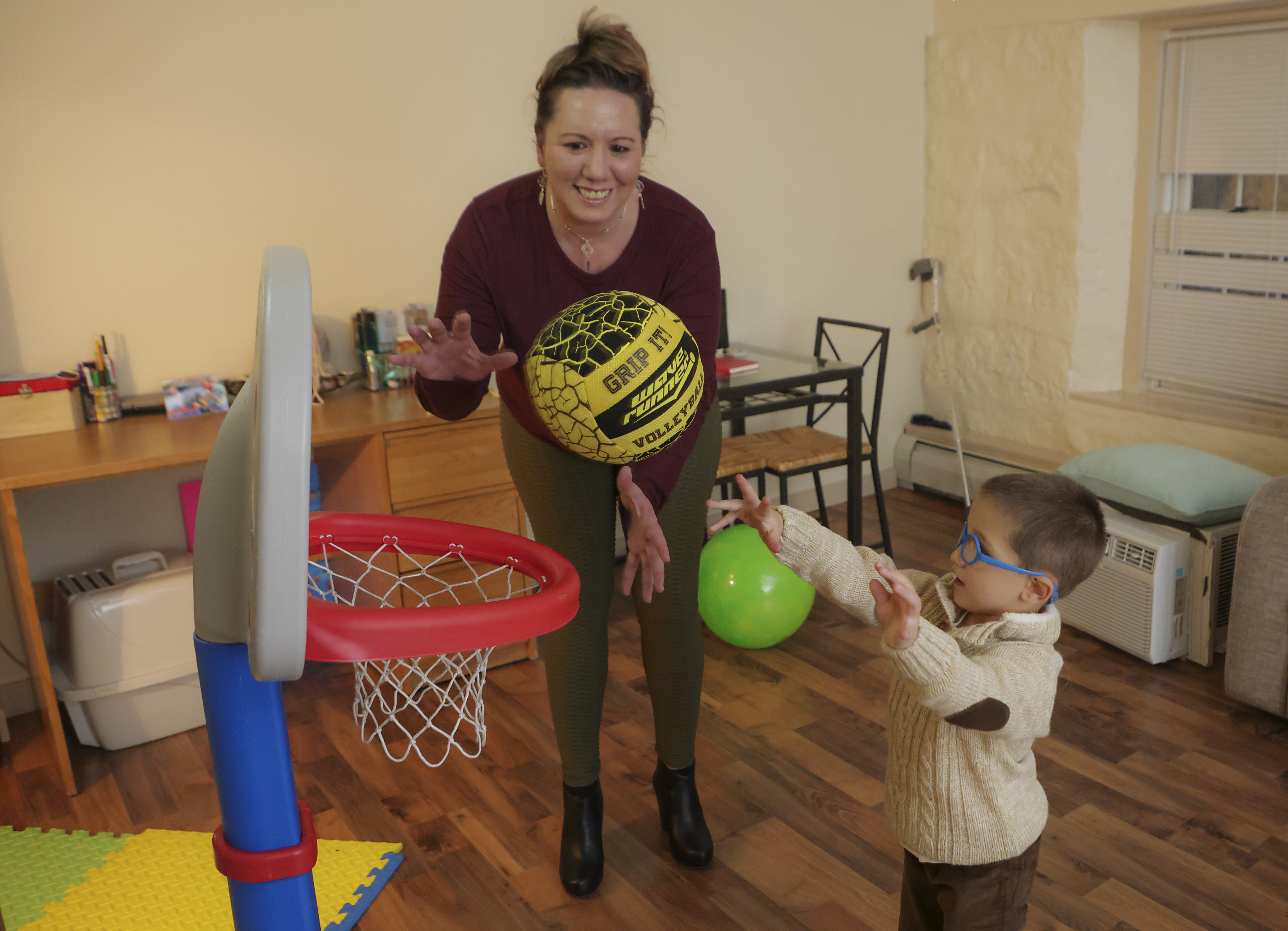Stephanie Lafleur playing basketball with her son, Devin LaFleur, 3, in their apartment.
