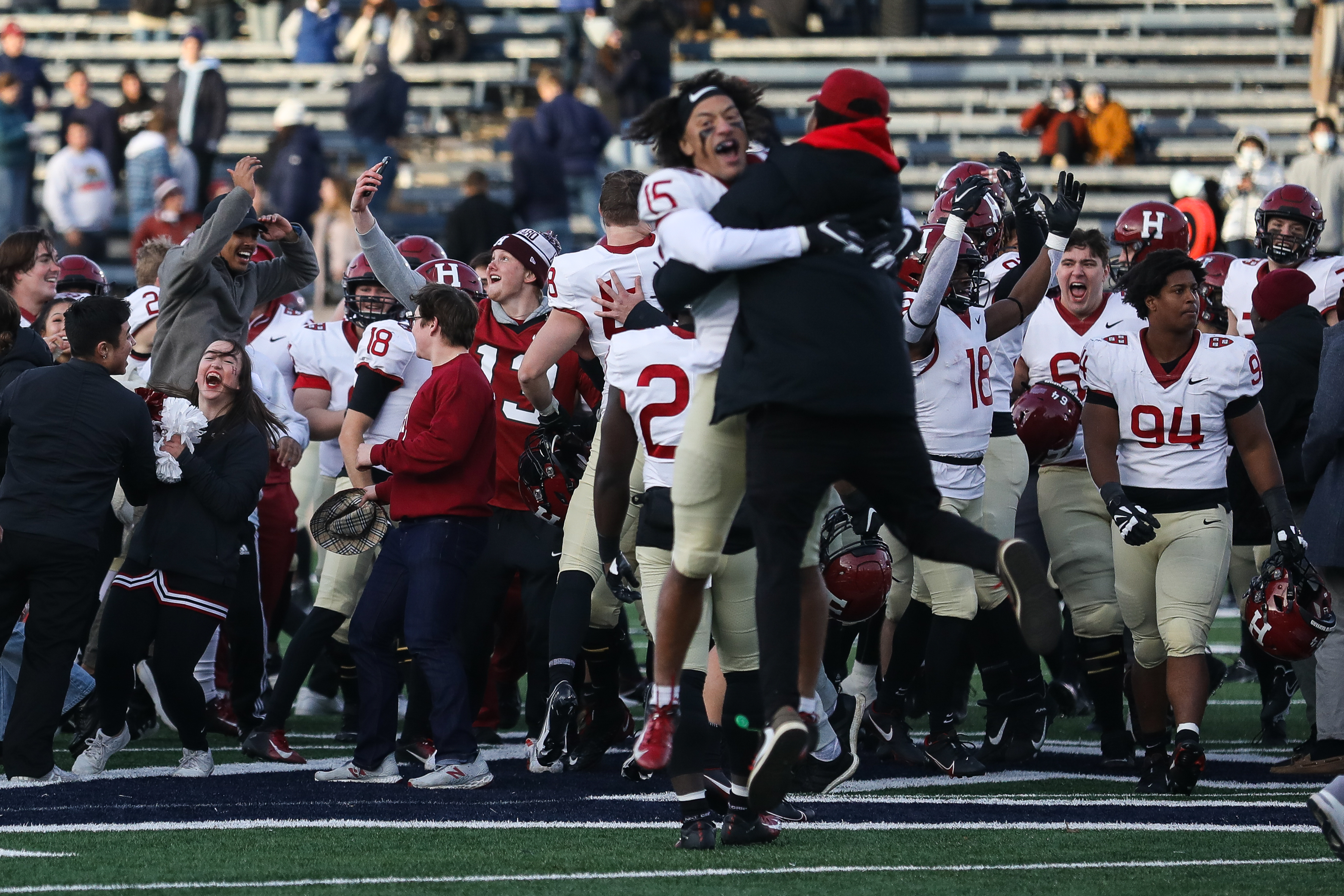 Harvard fans storm the field at the Yale Bowl to celebrate their team’s victory in New Haven, Conn.