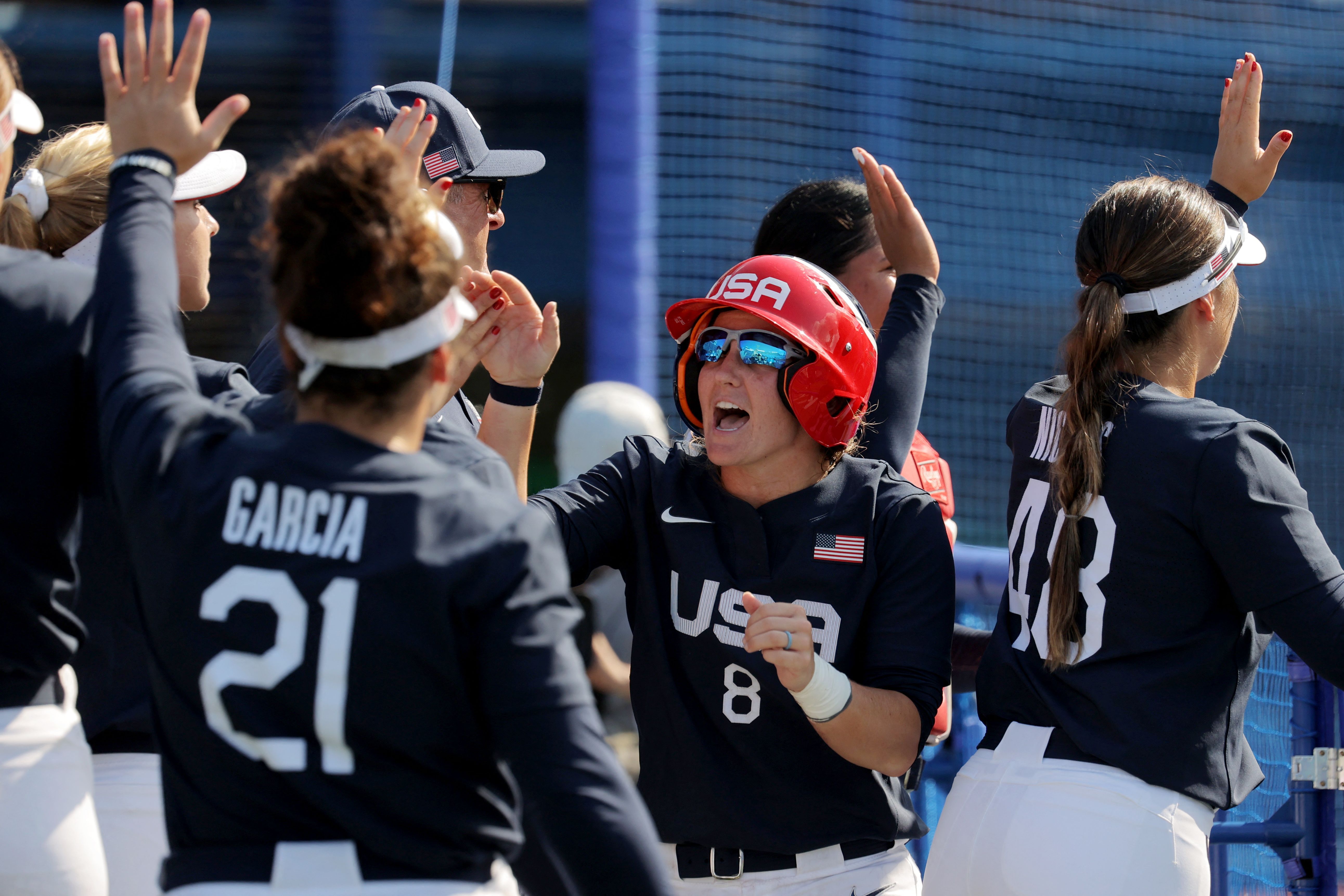 Haylie McCleney (in red batting helmet) celebrates after scoring against Mexico.