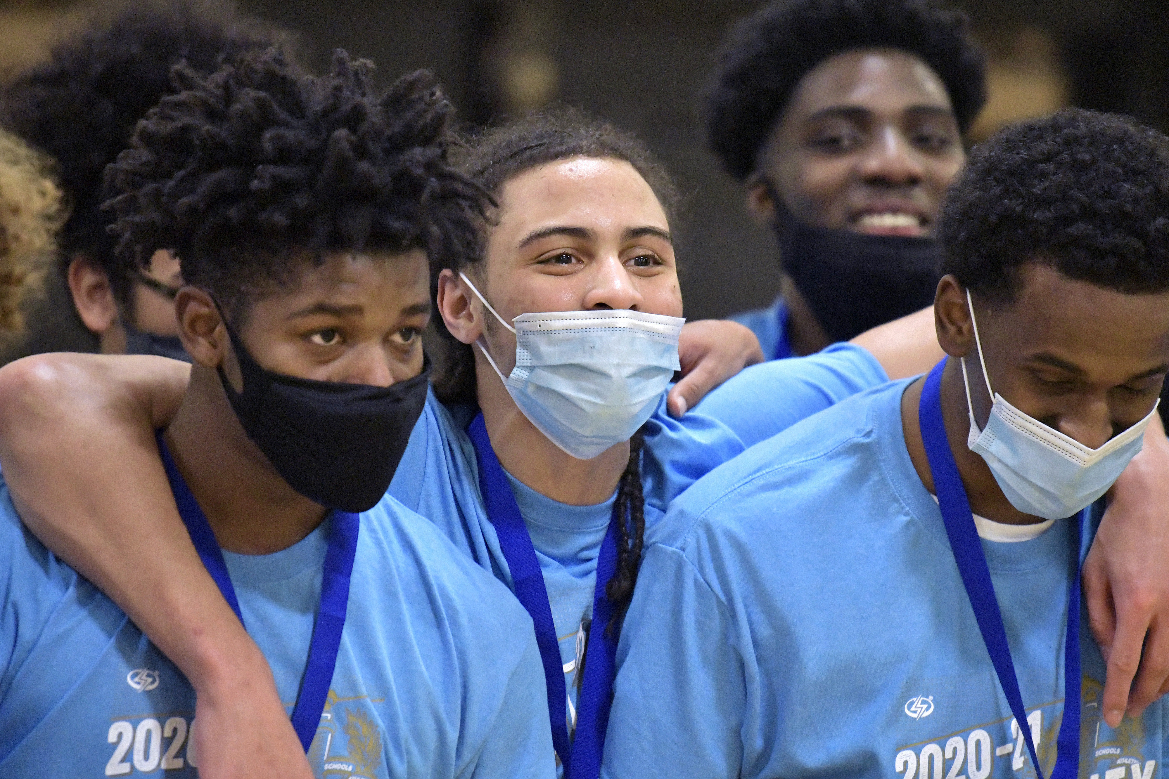Benny Martinez (center) celebrates with Latin Academy teammates following their Boston City League boys' basketball championship.
