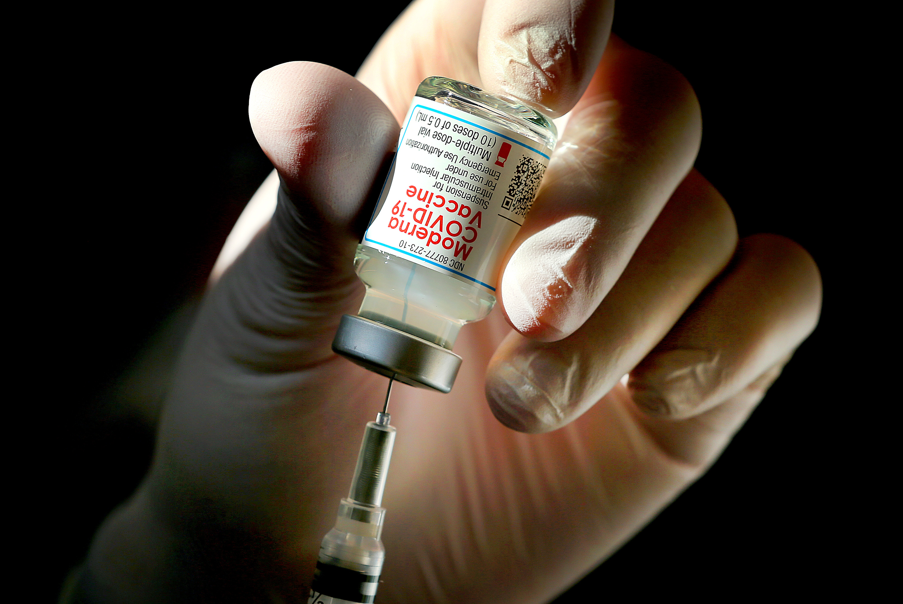 A COVID-19 vaccine, made by the Cambridge biotech company Moderna, was loaded into a syringe.