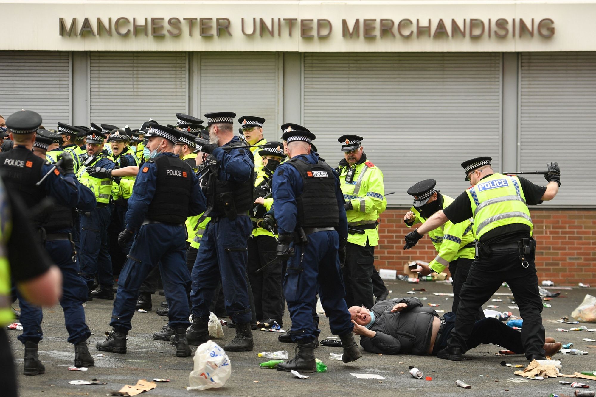 The first arrest has been made by Greater Manchester police after unrest at Old Trafford led to the postponement of Sunday's game between Manchester United and Liverpool.