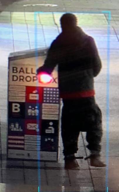 In this image released by the Boston Police Department, an individual is seen near a ballot box that authorities say was set on fire.