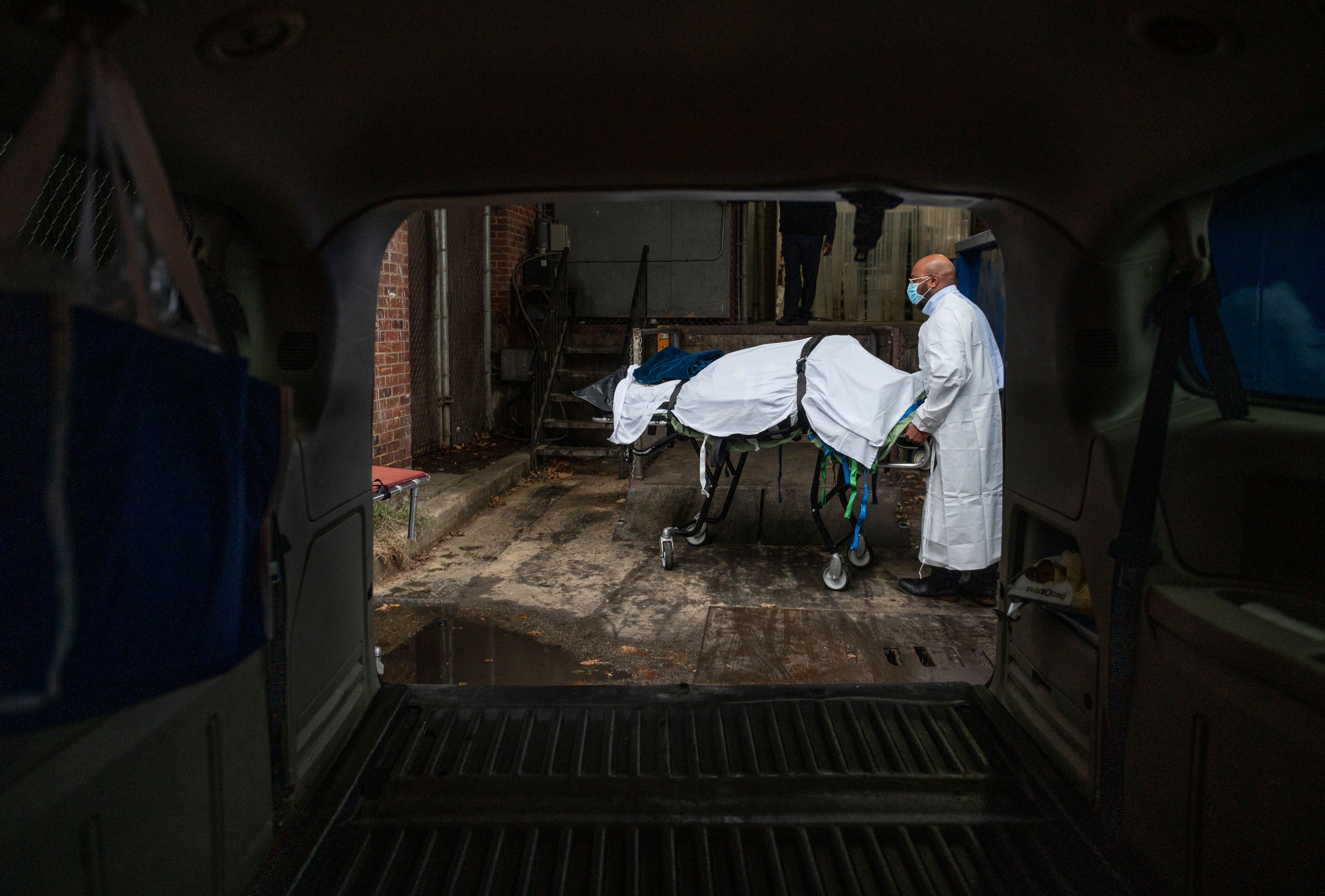 A Maryland cremation worker brought the body of a COVID-19 victim to a van in Baltimore in December.