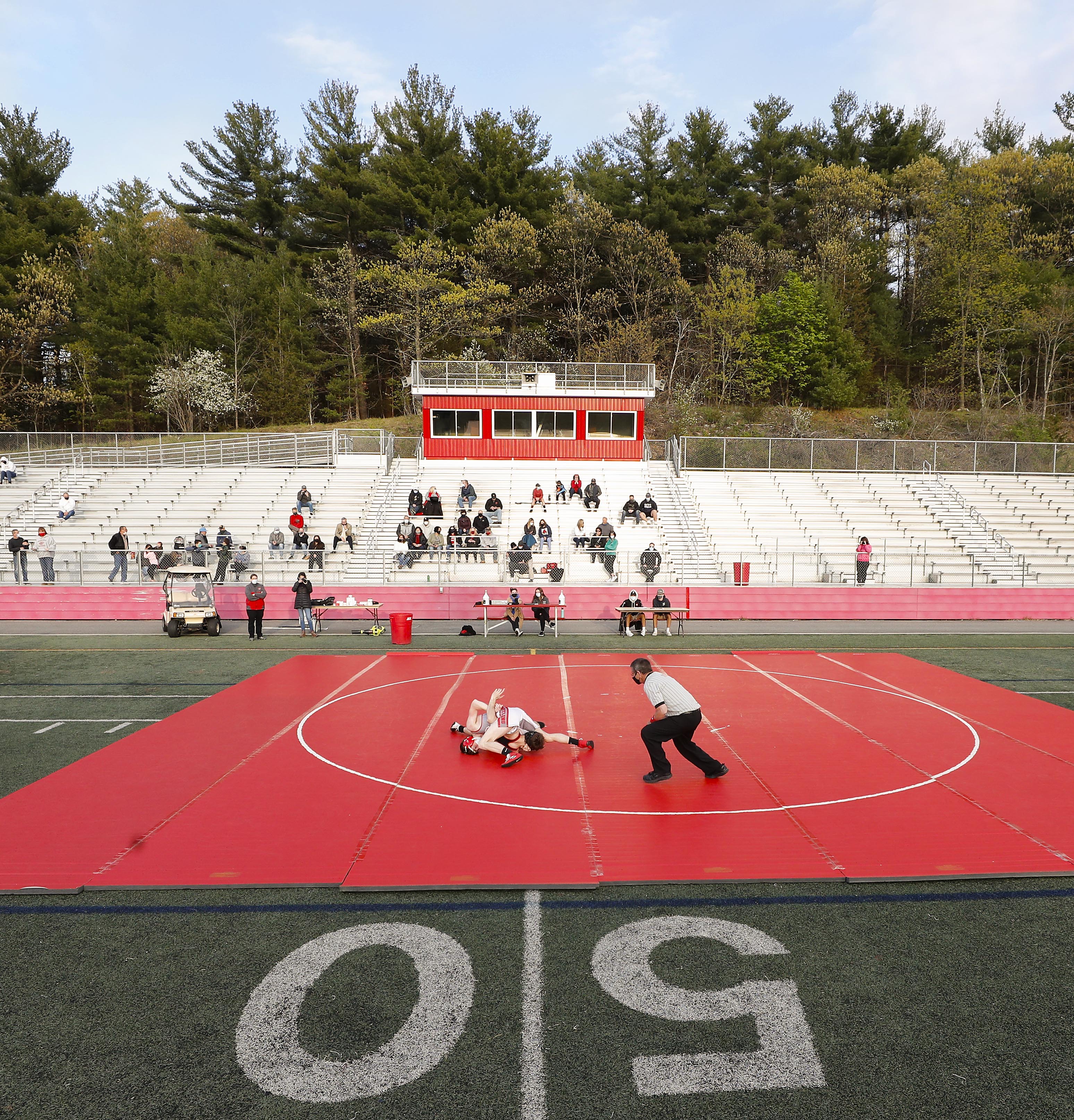 In a first-of-its-kind outdoor match under the lights, the Reading and Wakefield wrestling teams squared off on the 50-yard line of the football field Friday night.