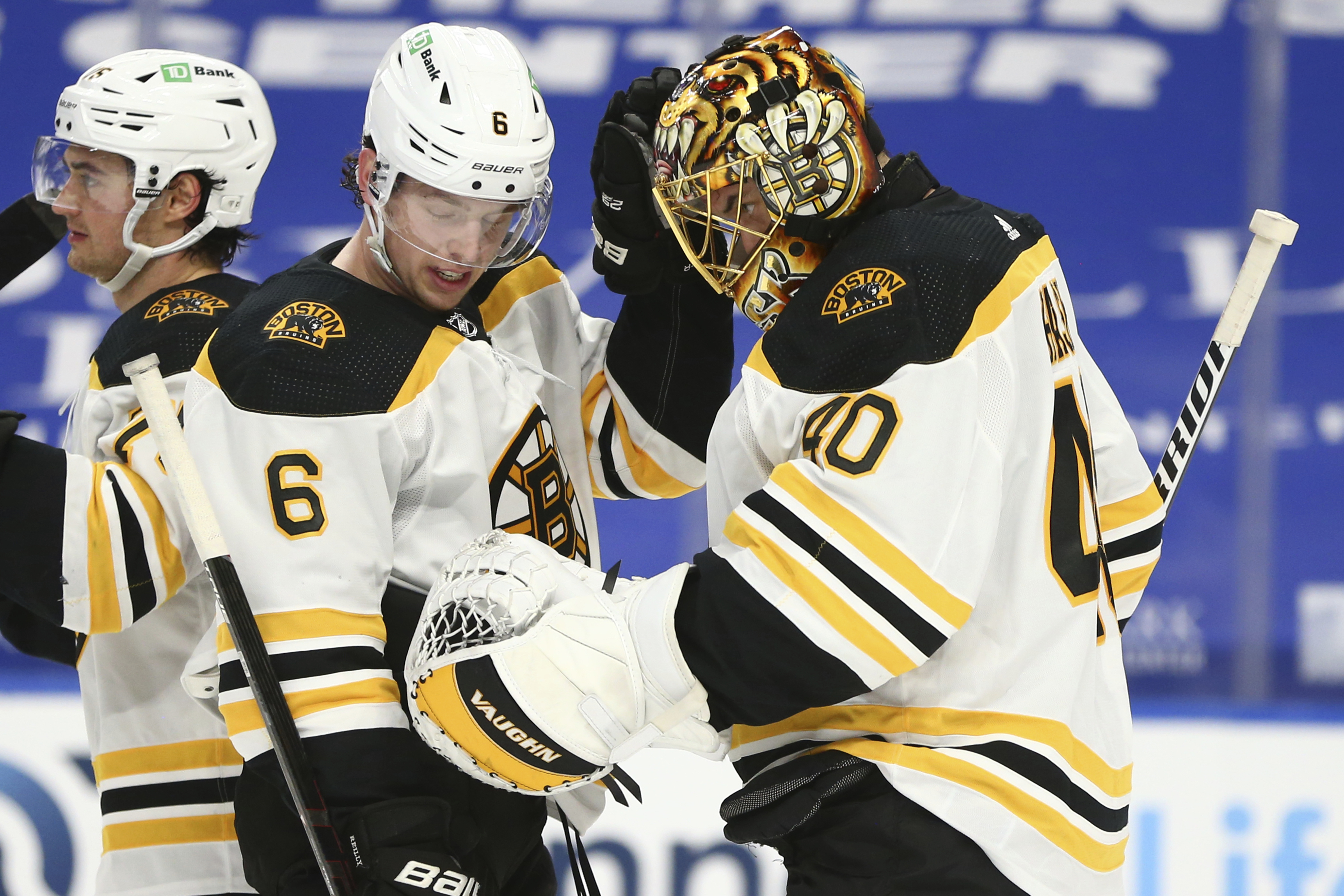 Tuukka Rask and Mike Reilly celebrate a victory over the Sabres Tuesday night.