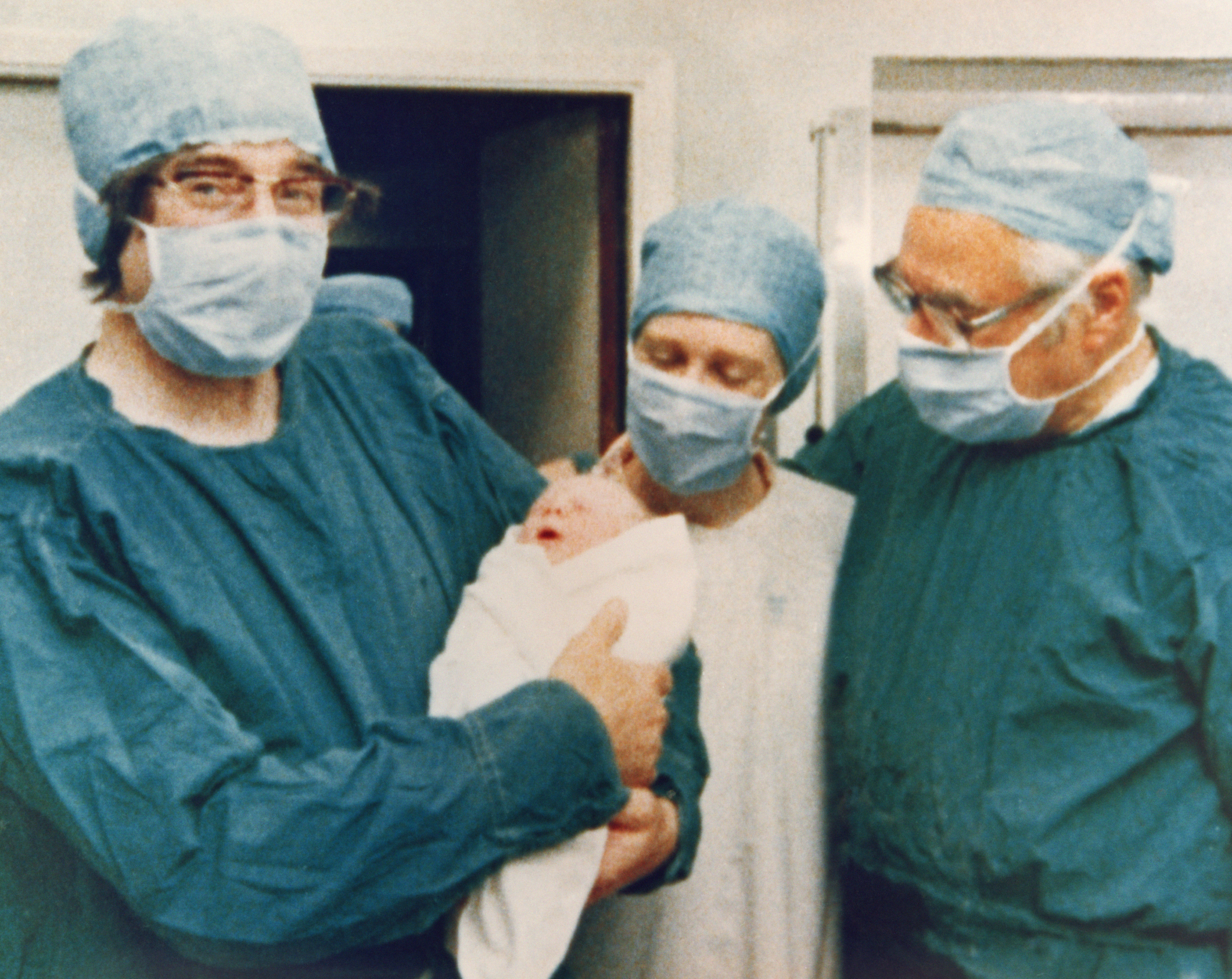 Dr. Robert Edwards, left, held Louise Joy Brown, the first baby born through in vitro fertilization, in 1978.