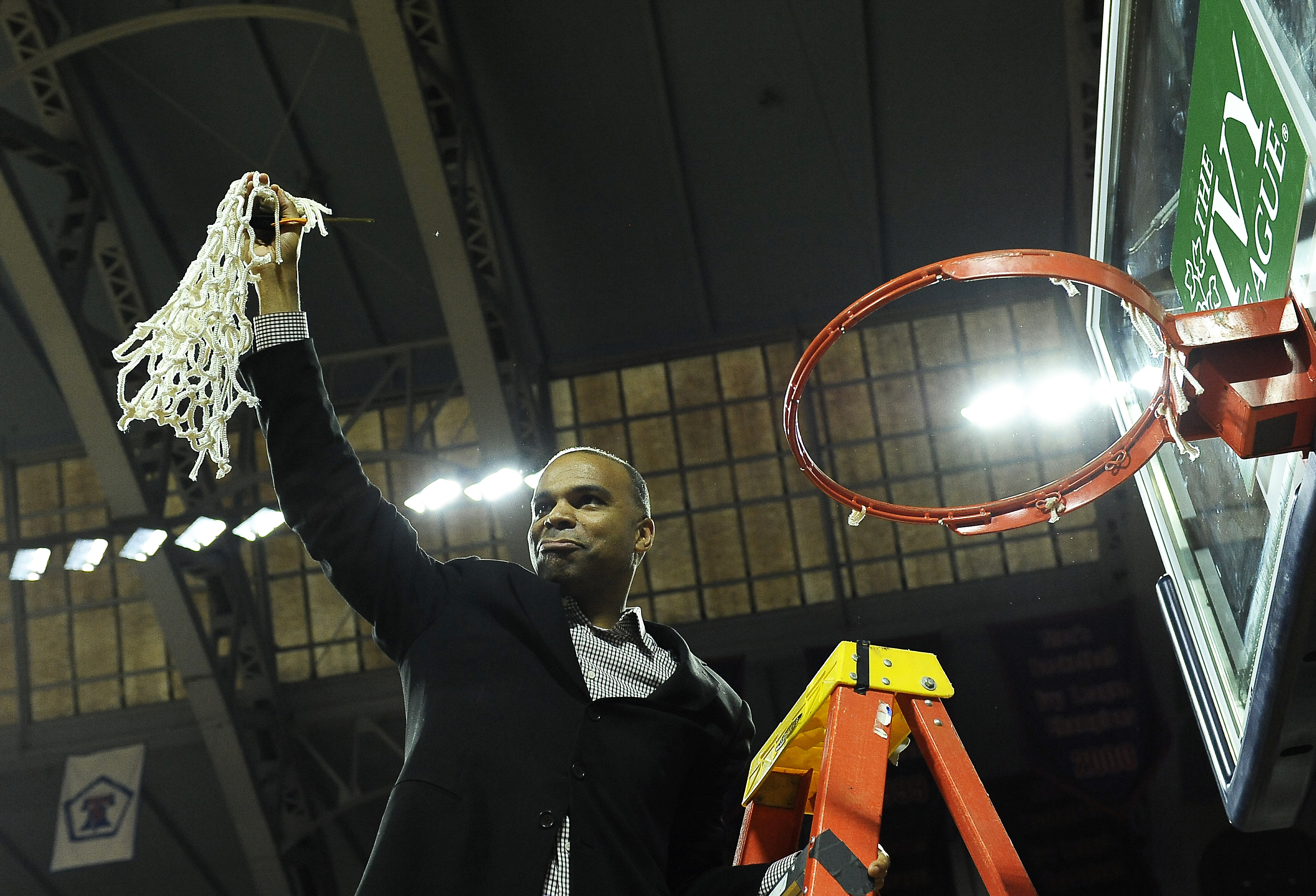 Harvard head coach Tommy Amaker cuts down the net after his team defeated Yale for the Ivy League championship in 2015.