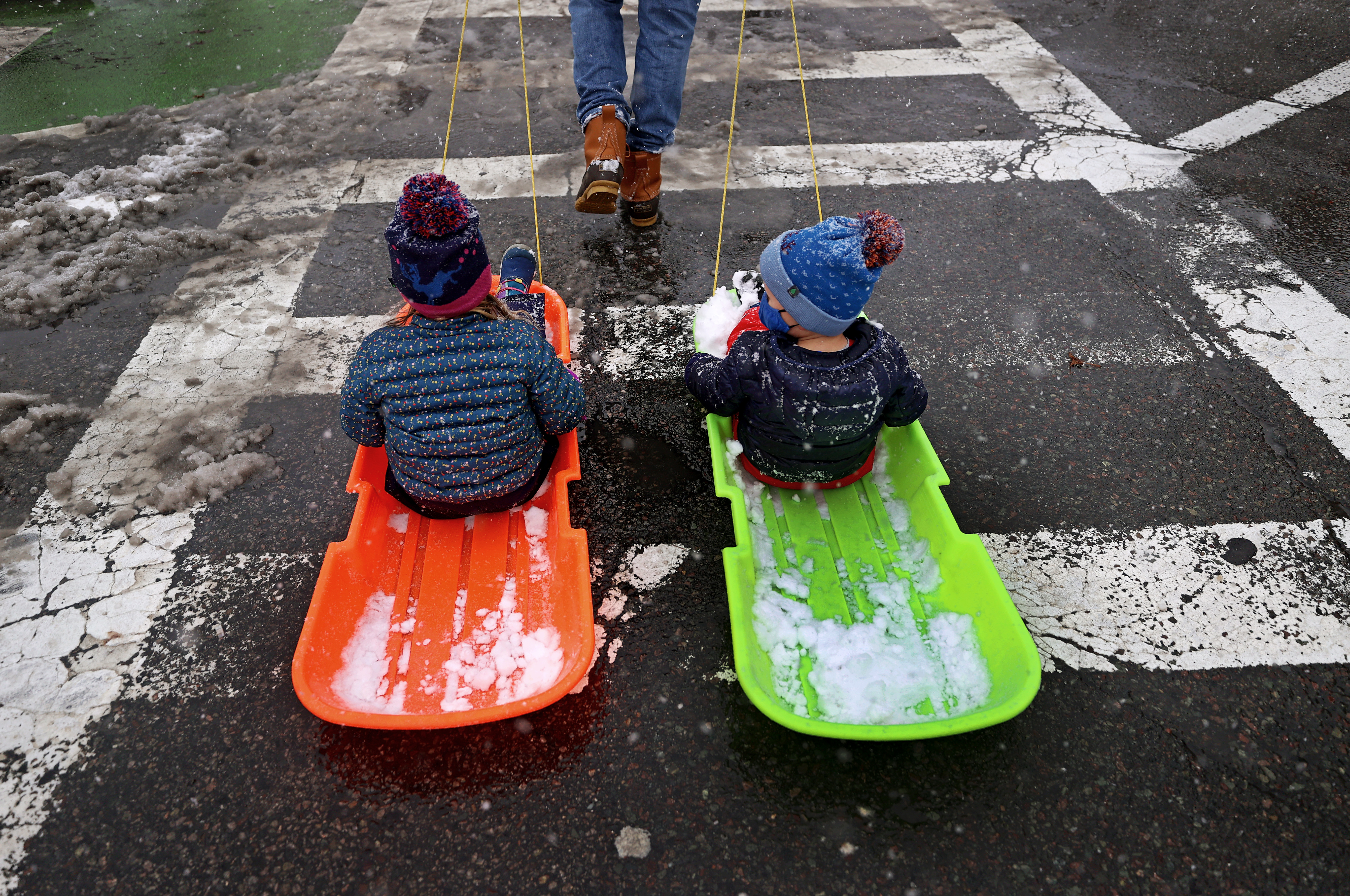 Lauren and her brother Gus are towed by their father Ted through Charles Street in Boston after sledding.