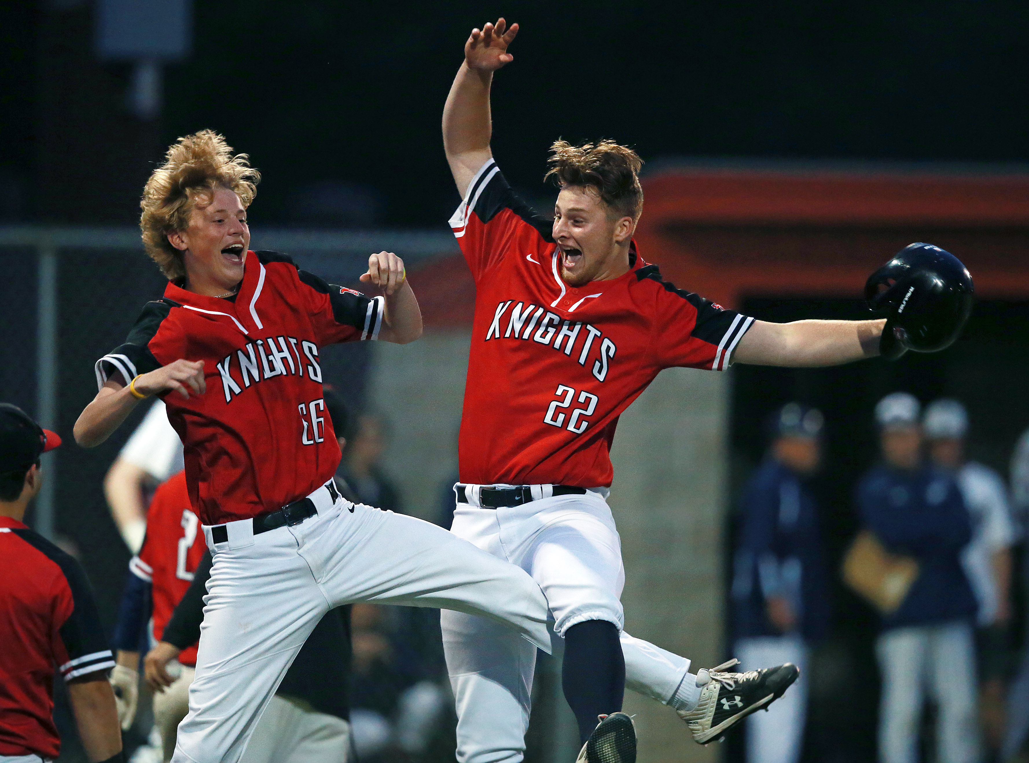 North Andover’s Eric Whitehead (22), who had just hit a top of the 6th inning RBI double to put his team ahead 2-0, was greeted by a leaping teammate Ryan Griffin when he came back to the dugout after being lifted for a pinch runner during the Super 8 baseball final at Trinity Stadium in Haverhill on June 18. North Andover won, 6-0.