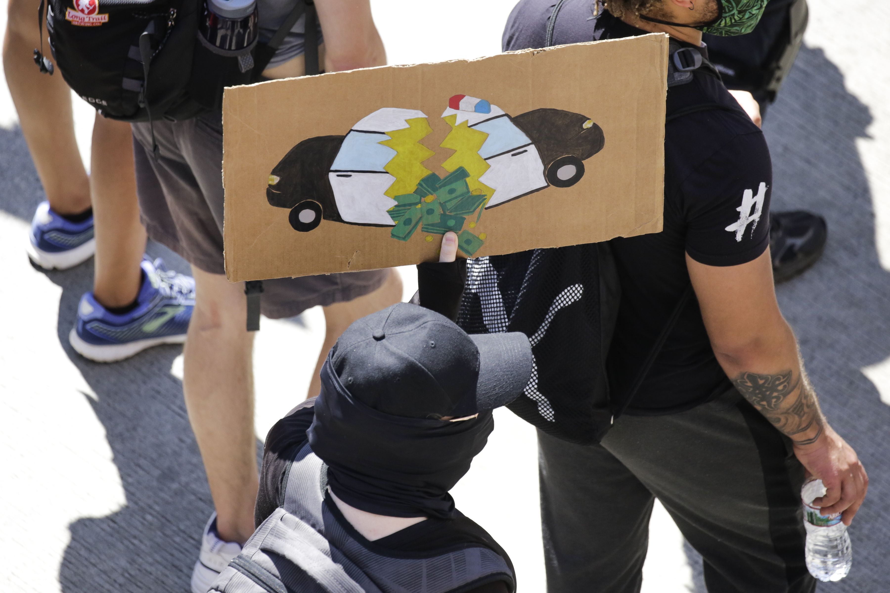 A protester carried a sign during a "Defund the Police" march from King County Youth Jail to City Hall in Seattle on Aug. 5.