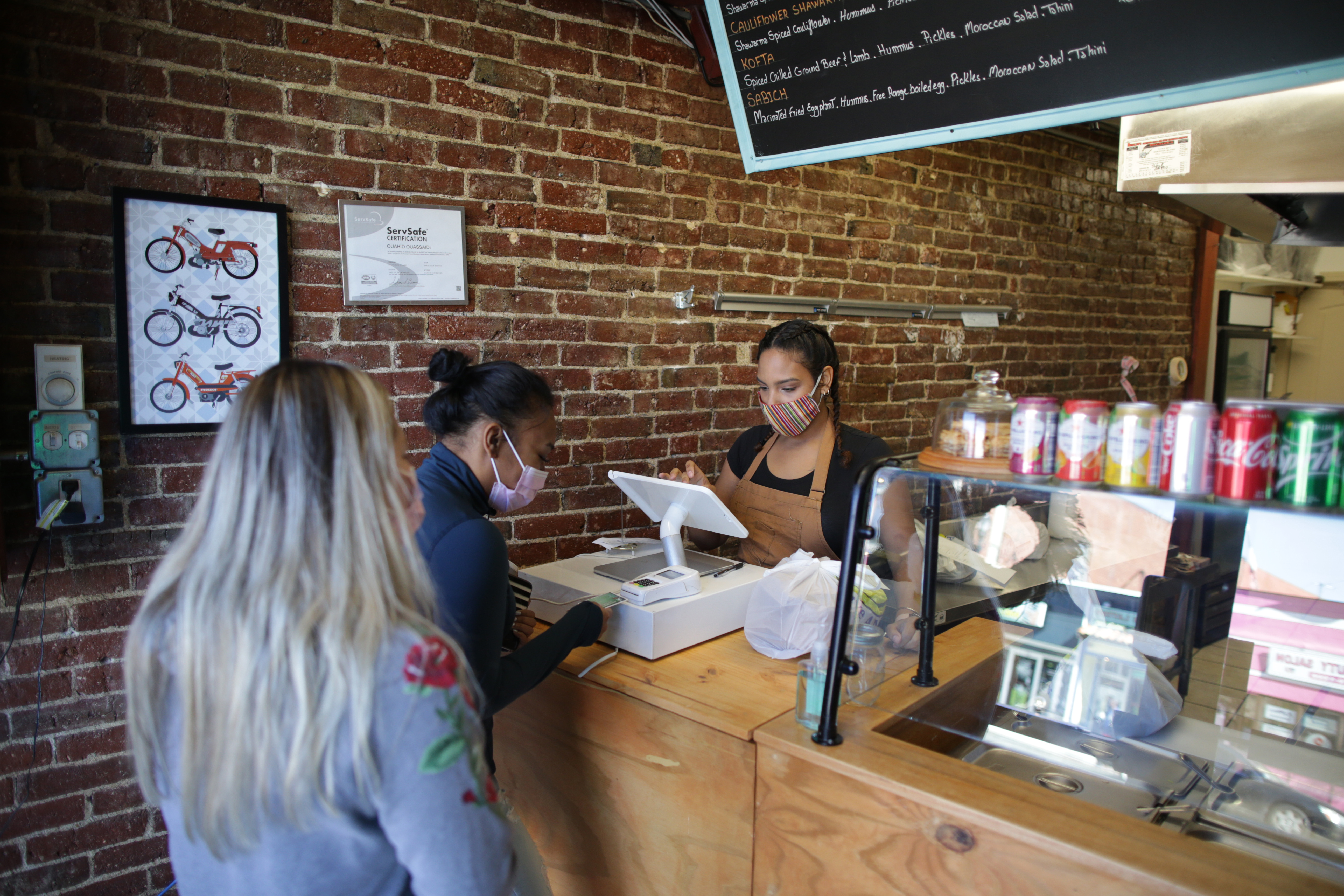 Sandra L Naranjo Fontanez waits on customers at Kous Kous, a restaurant in downtown Framingham.