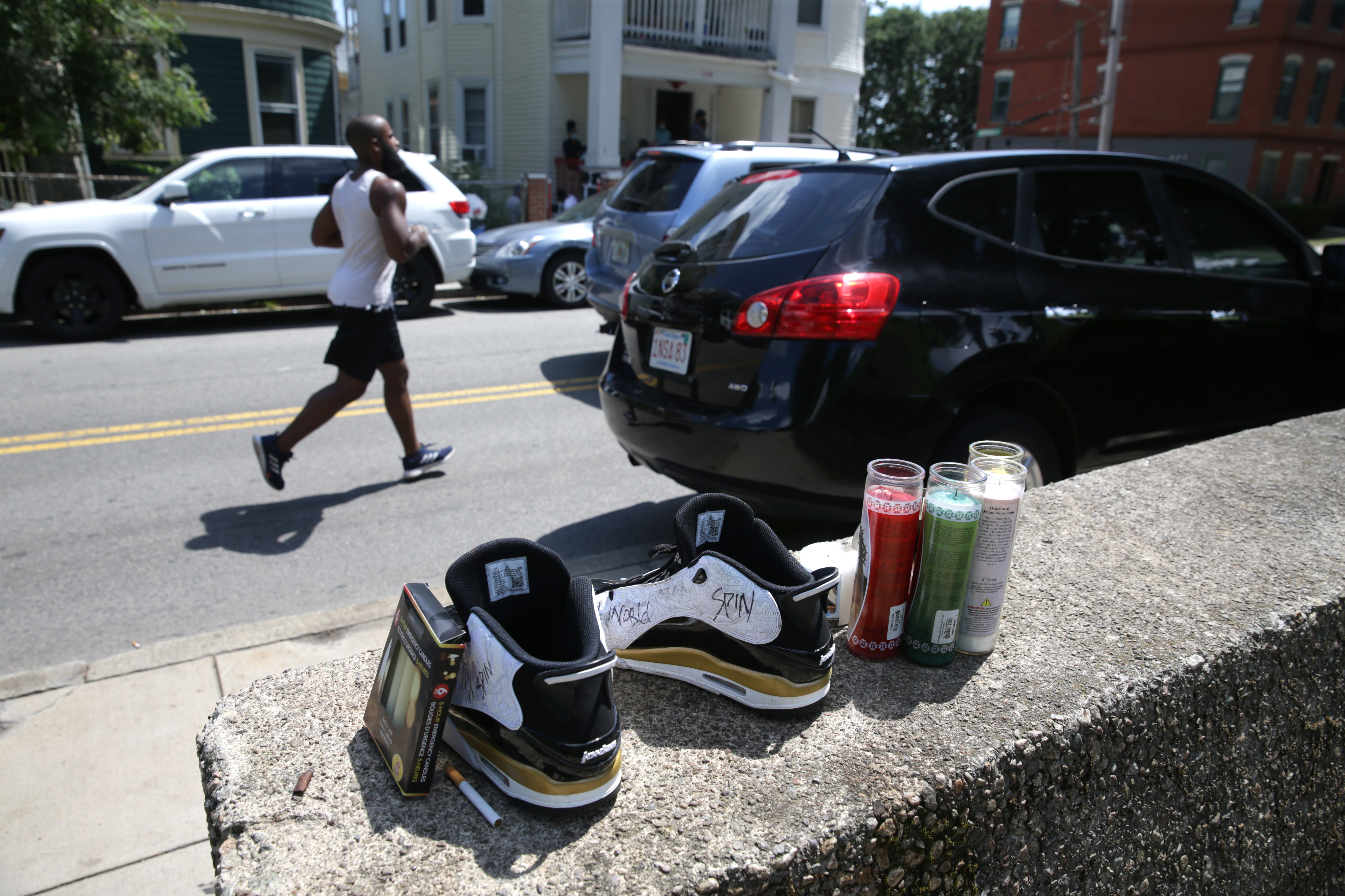 A jogger passed by a makeshift memorial near the 100 block of Adams Street near Ronan Park in Dorchester in July.
