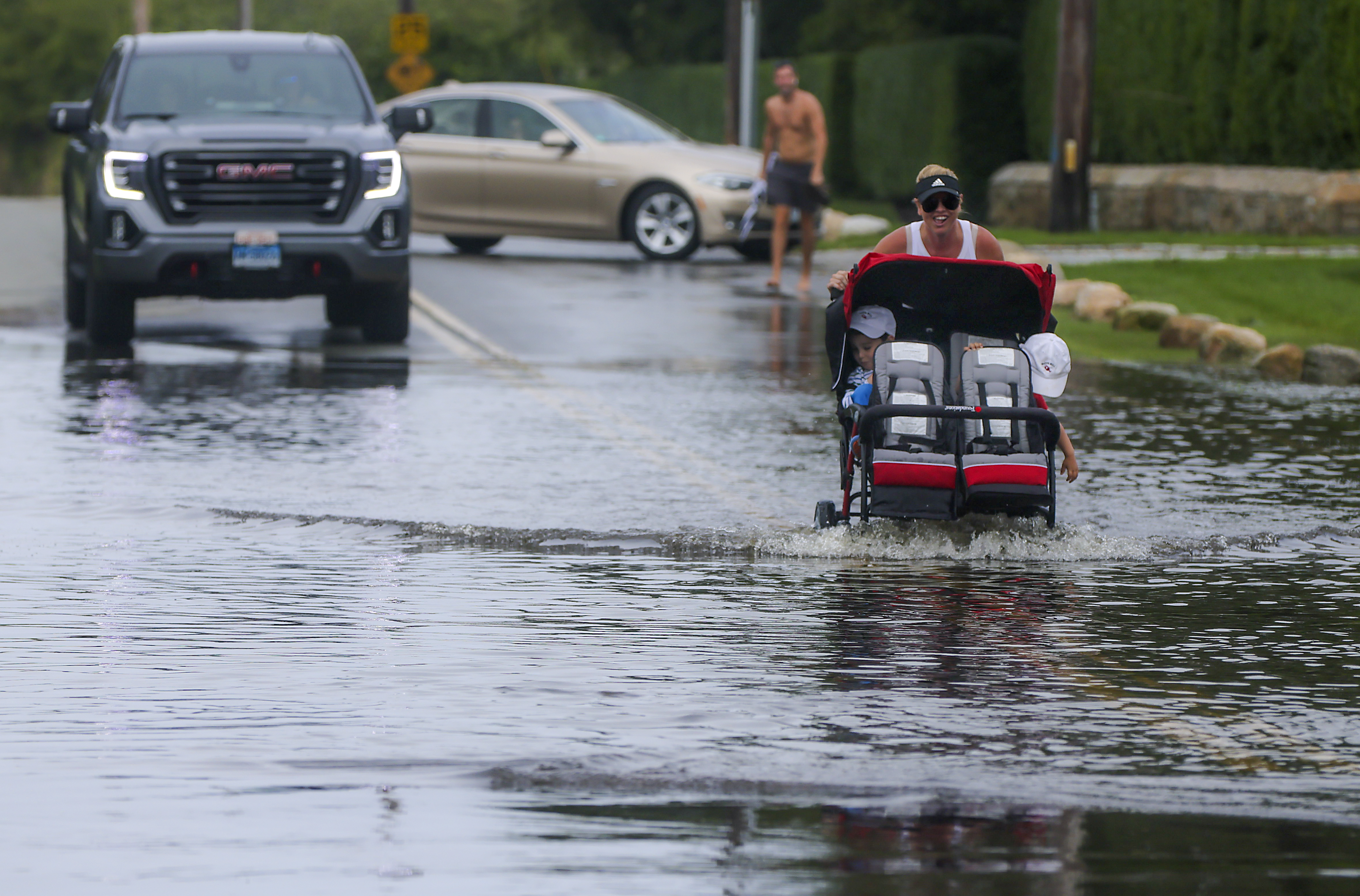 Heather Roberts pushed Thomas Reycraft, 4, and his brother William, 2, through a huge puddle on Ocean View Highway after Tropical Storm Henri.