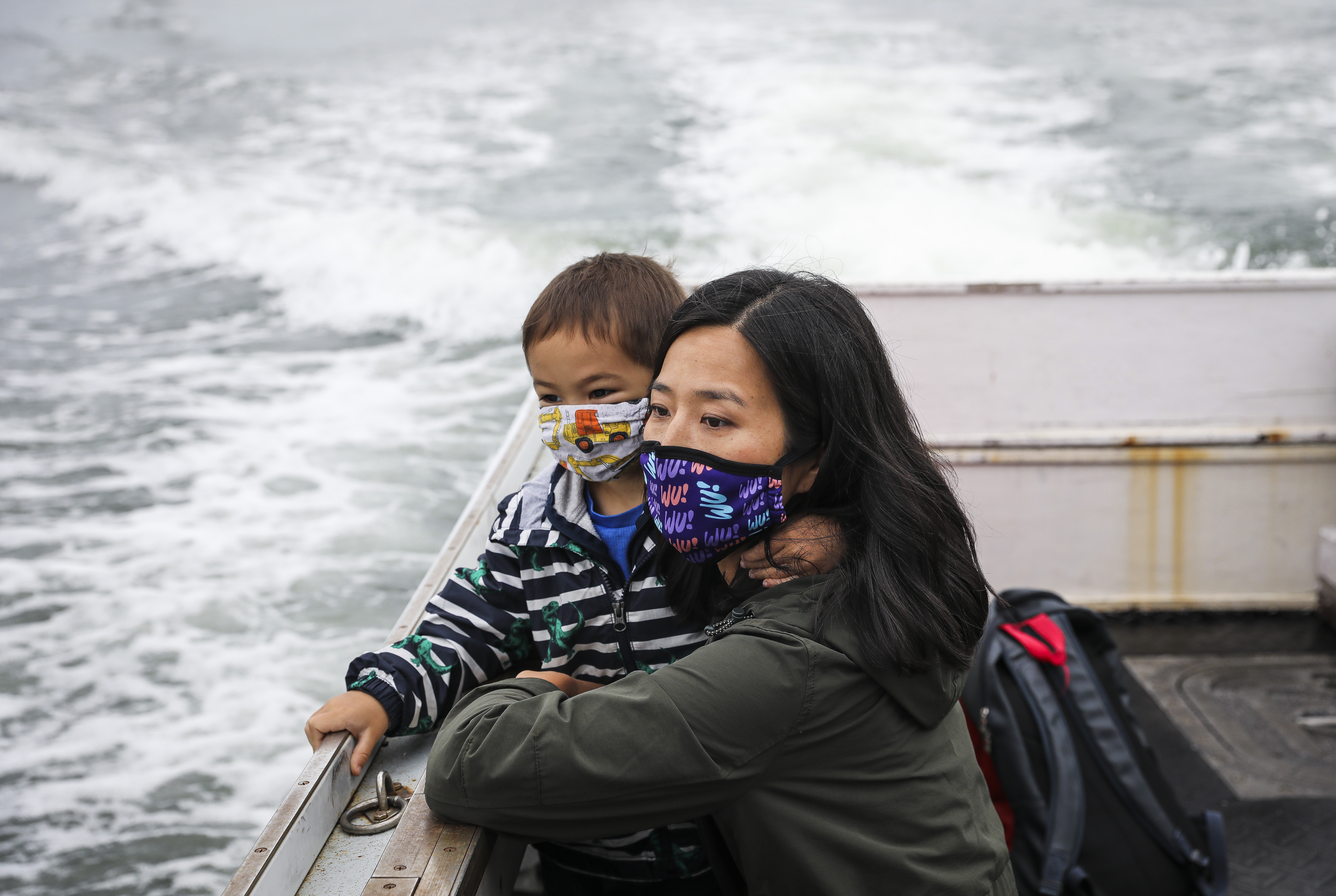 Boston City Councilor Michelle Wu looks out across the water with her 3-year-old son Cass while they head to Thompson Island for a campaign stop.