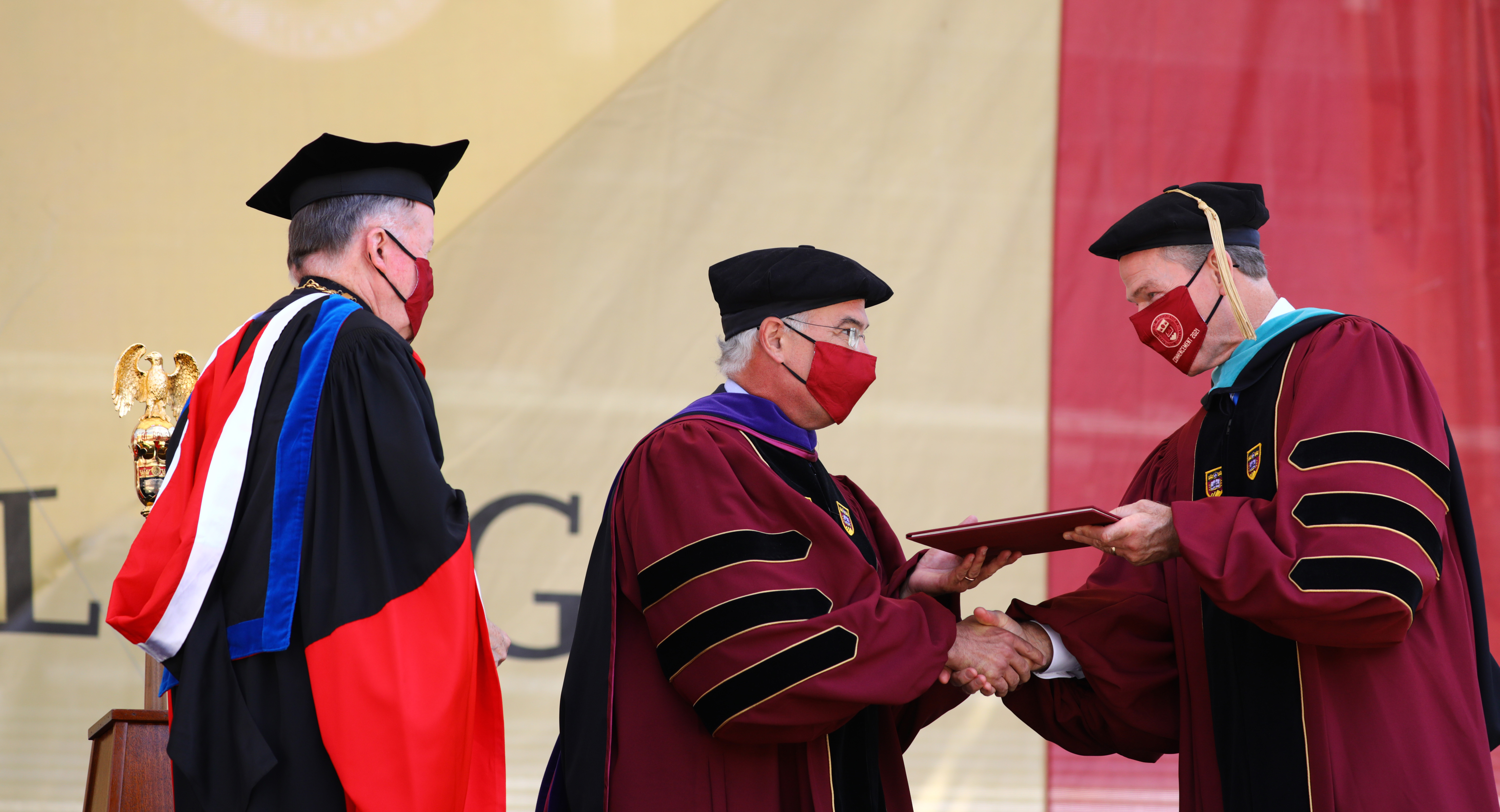After being hooded by President William P. Leahy, S.J., PH.D., David Brooks accepted his honorary degree from Board of Trustees chair John F. Fish.