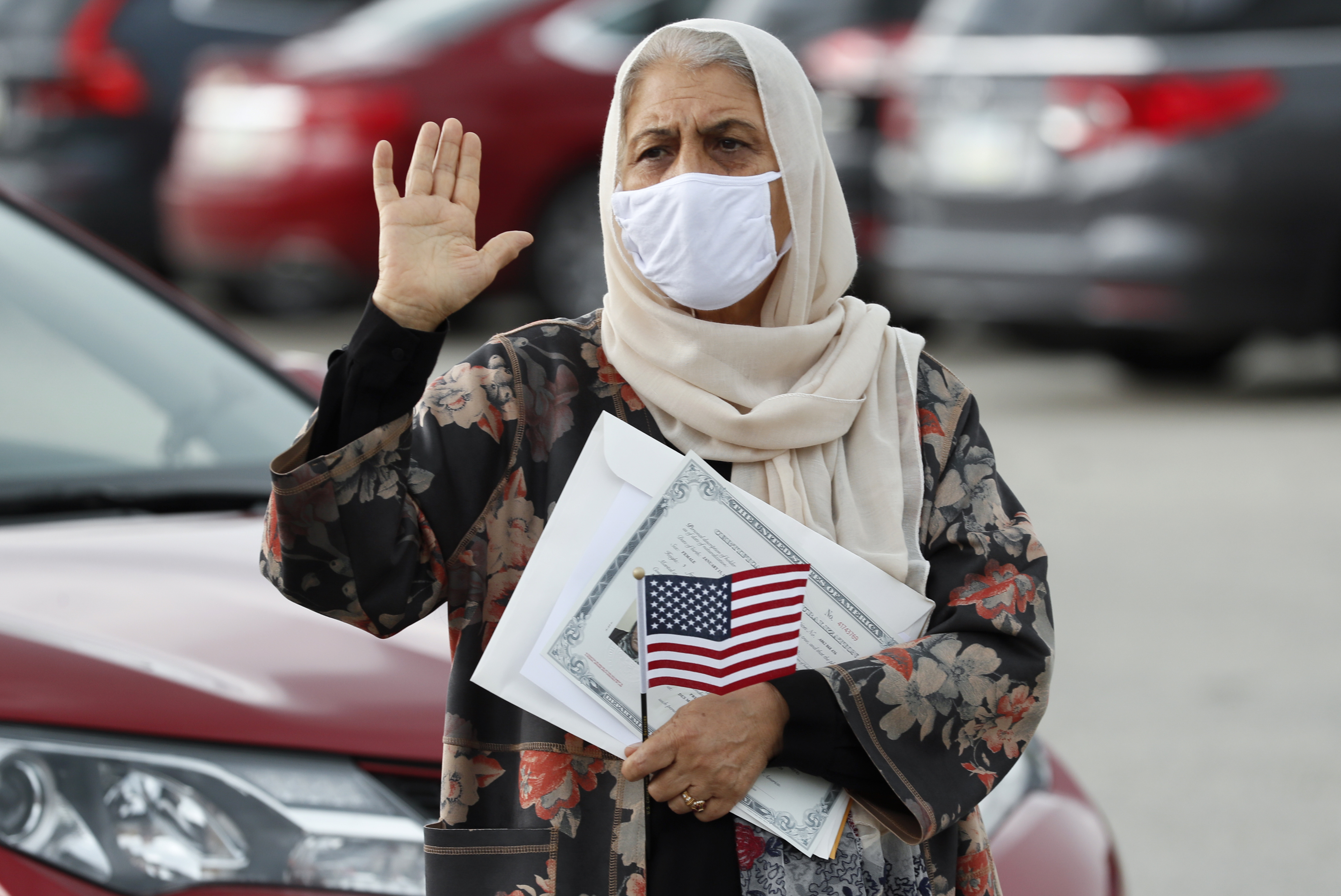 Aisha Kazman Kammawie takes the Oath of Allegiance during a drive-thru naturalization ceremony at Principal Park, Friday, June 26, 2020, in Des Moines, Iowa.