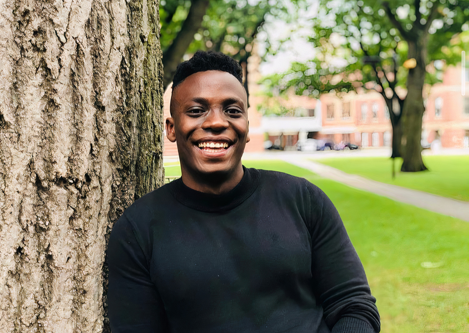 SocialCall founder Kaluwe Muntanga leaning against a tree.