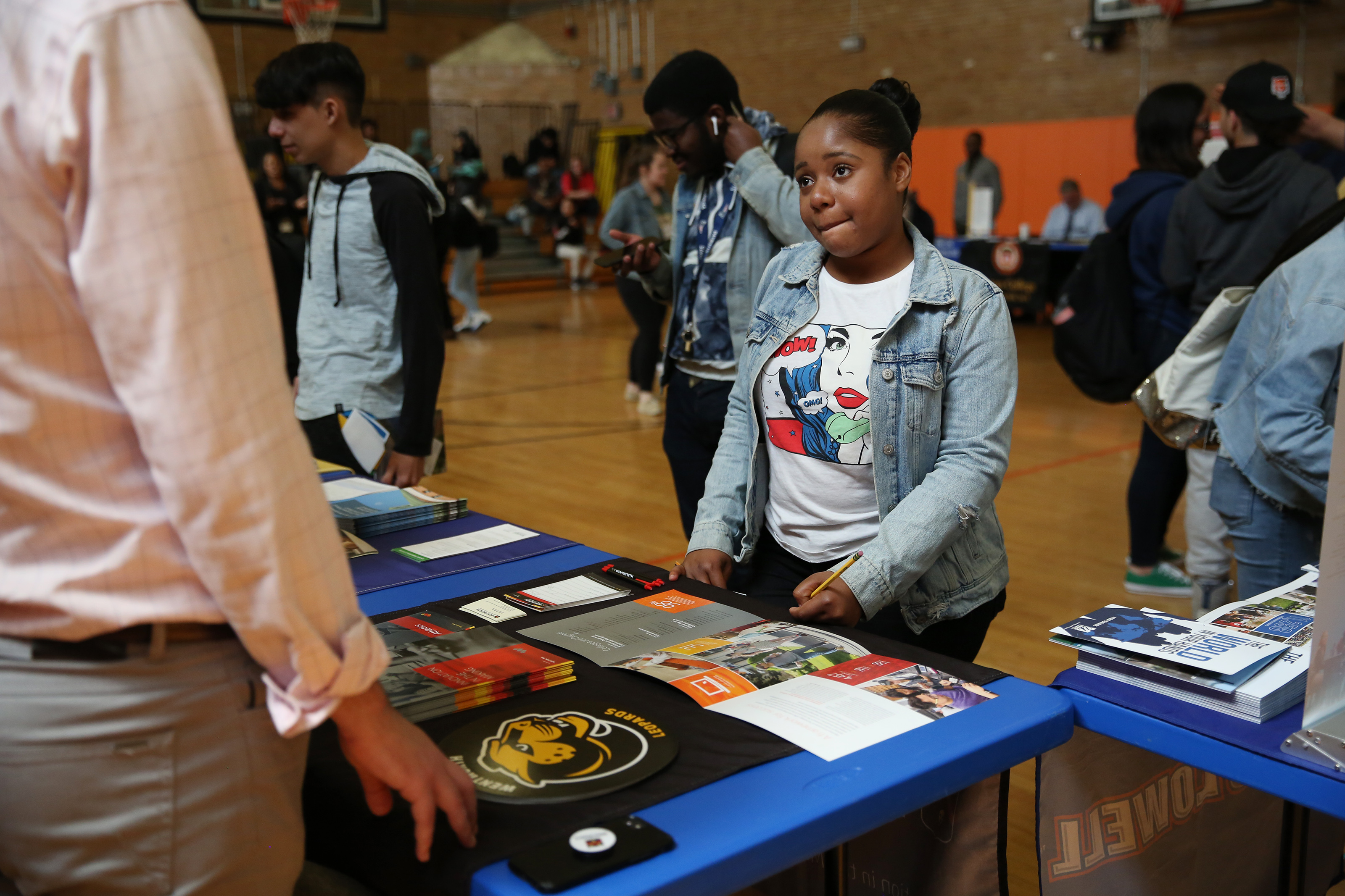 ESL student Chrystellie Melay listened as a college representative talked about what classes she might take to earn a scholarship during a college fair at Brighton High School.