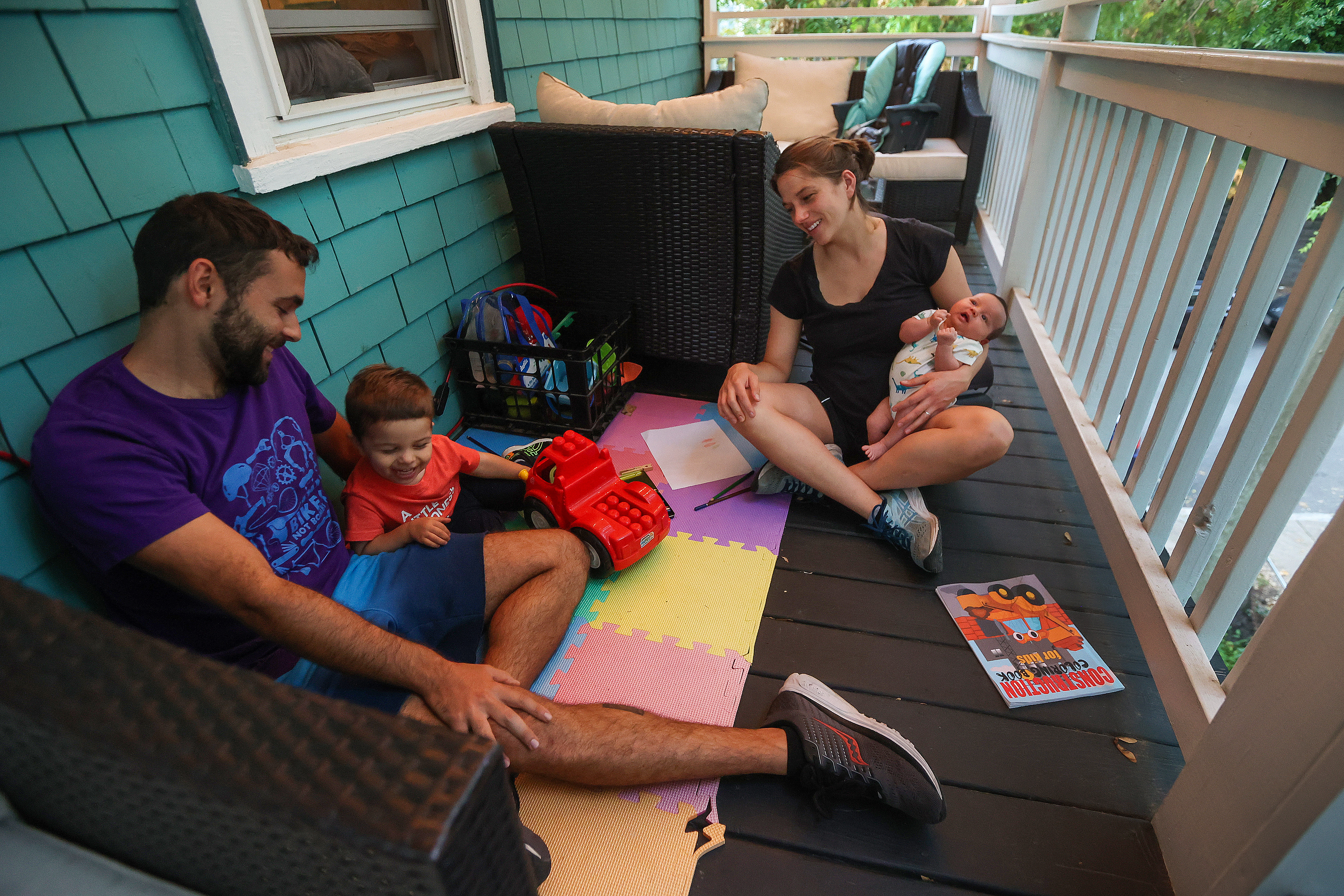 Zack DeClerck, 29, relaxing on the porch in Jamaica Plain with his wife, Maddie and children Skylar, 2, and Zoe 4 weeks old, believes "a denser neighborhood is a greener one."