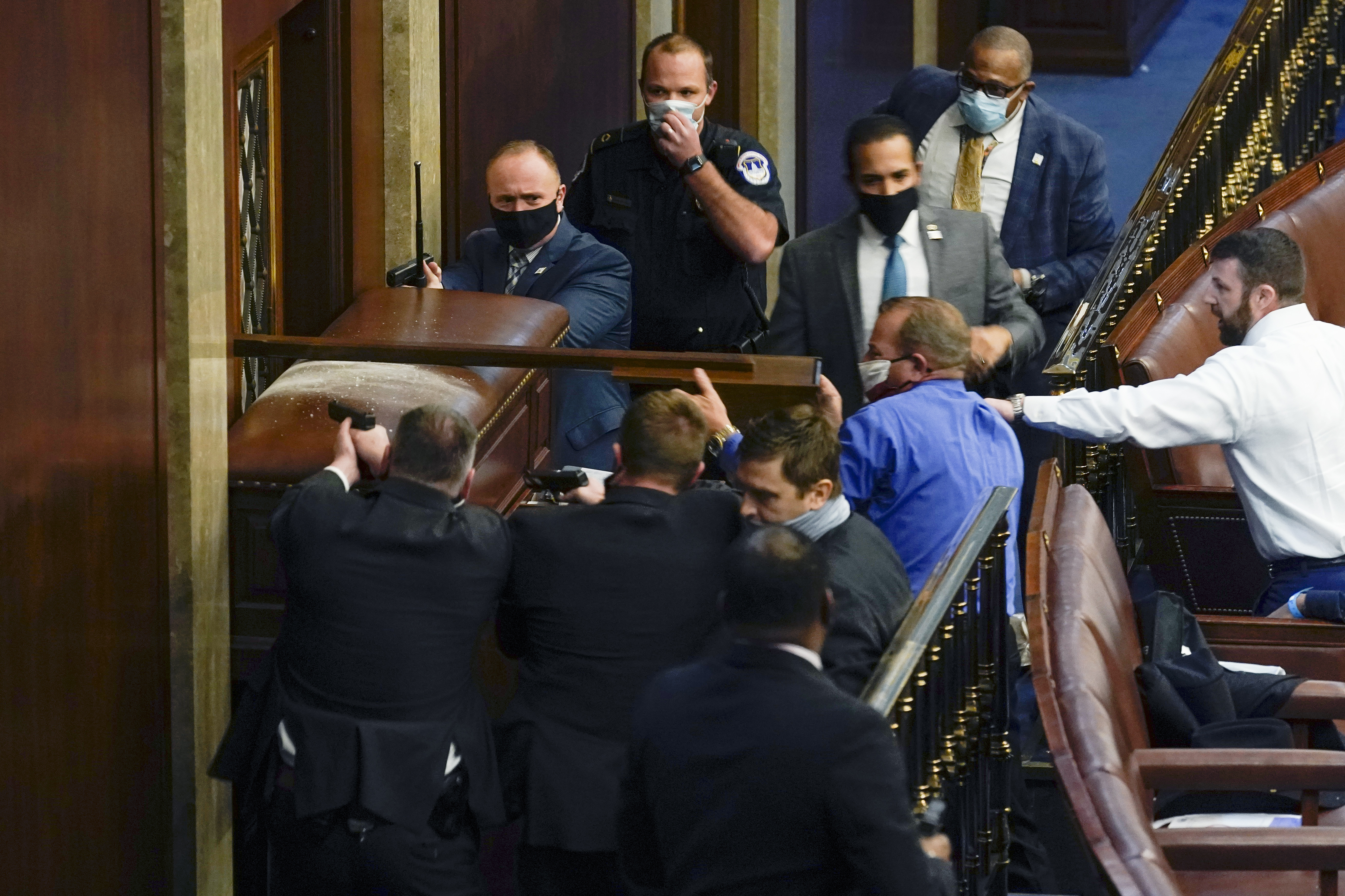 Capitol Police with guns drawn stood near a barricaded door as rioters tried to break into the House Chamber at the US Capitol on Jan. 6.