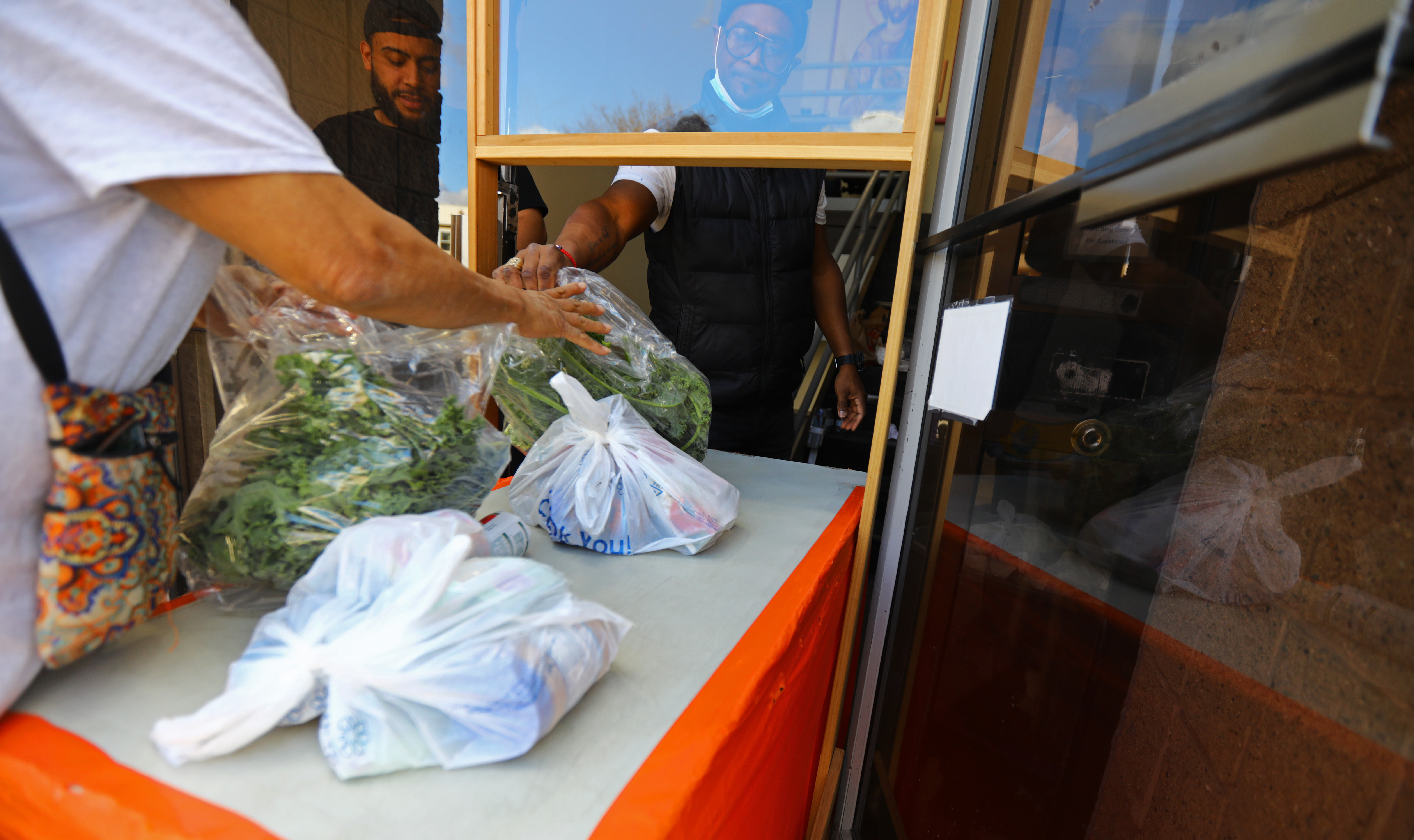 Guests receive items from St. Martha’s Food Pantry of Lazarus House Ministries in Lawrence.