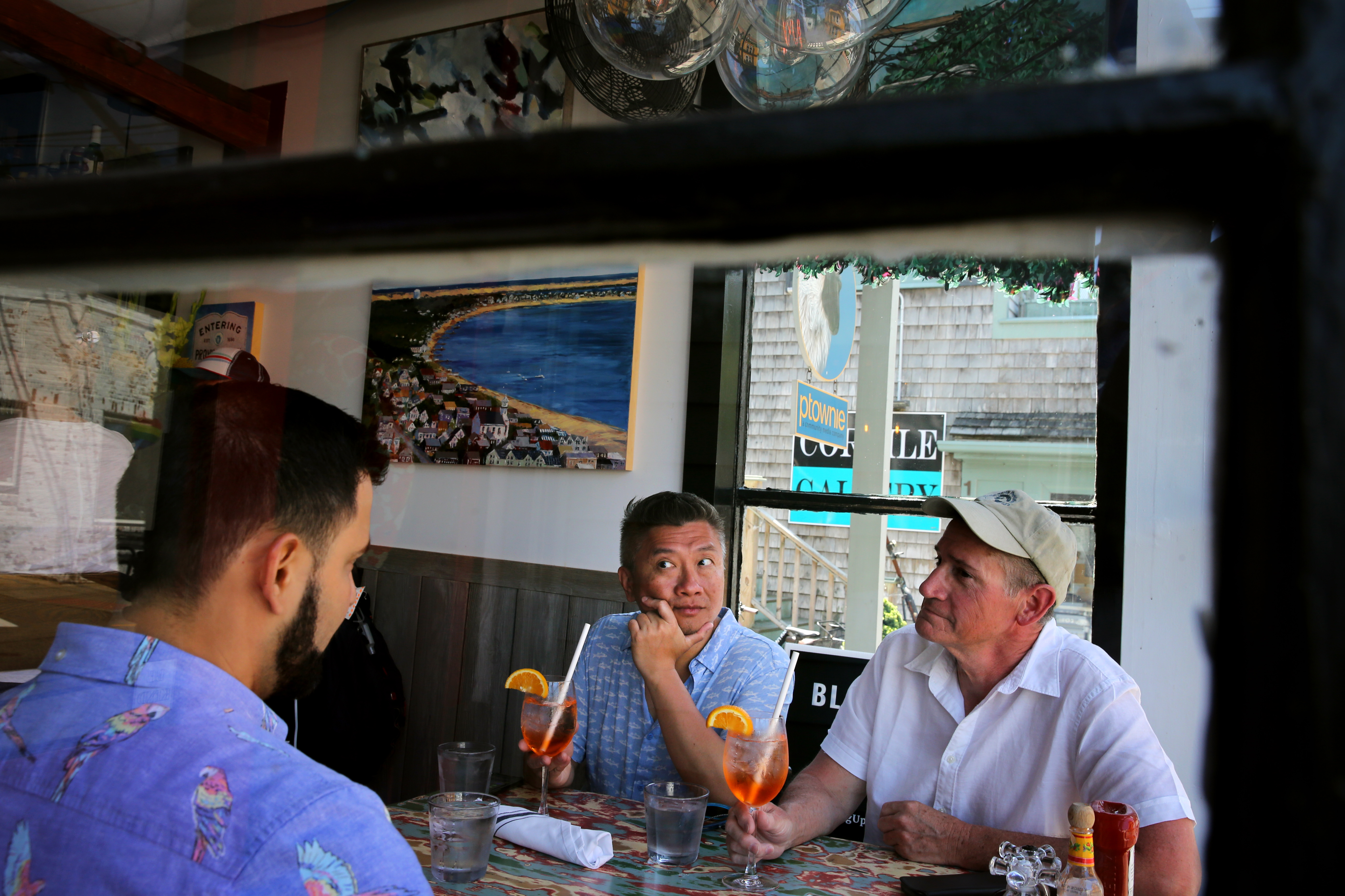 From left, Elias Contreras, Ken Ng, and Charles McFerrin ate lunch at the Heaven Cafe in Provincetown on Saturday The restaurant asks customers to wear masks unless they are seated.
