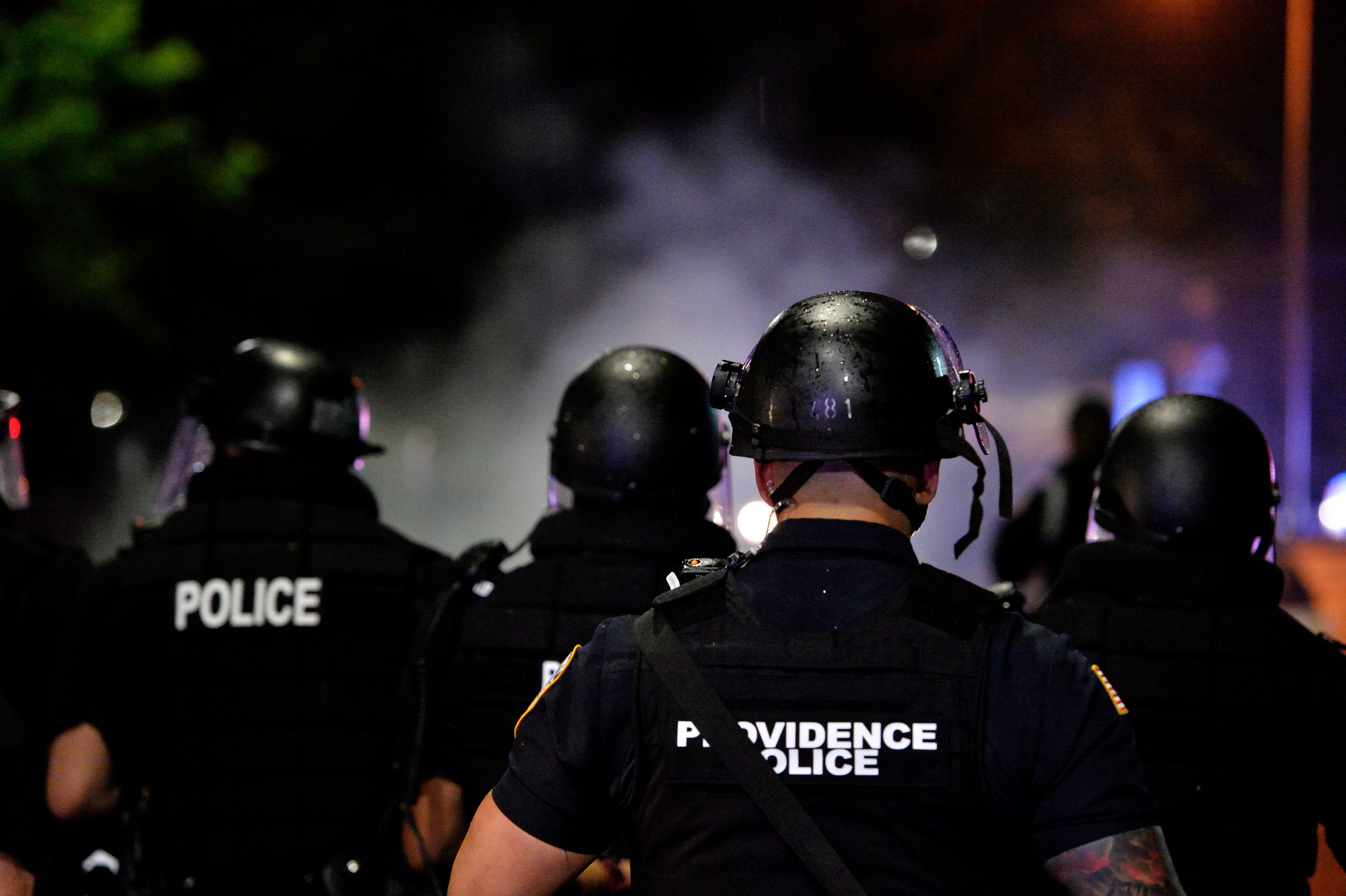 Police officers and National Guard soldiers make their way through a smoke filled street as they chase and confront protesters after curfew and after a peaceful Black Lives Matter rally in Providence, Rhode Island on June 5, 2020.