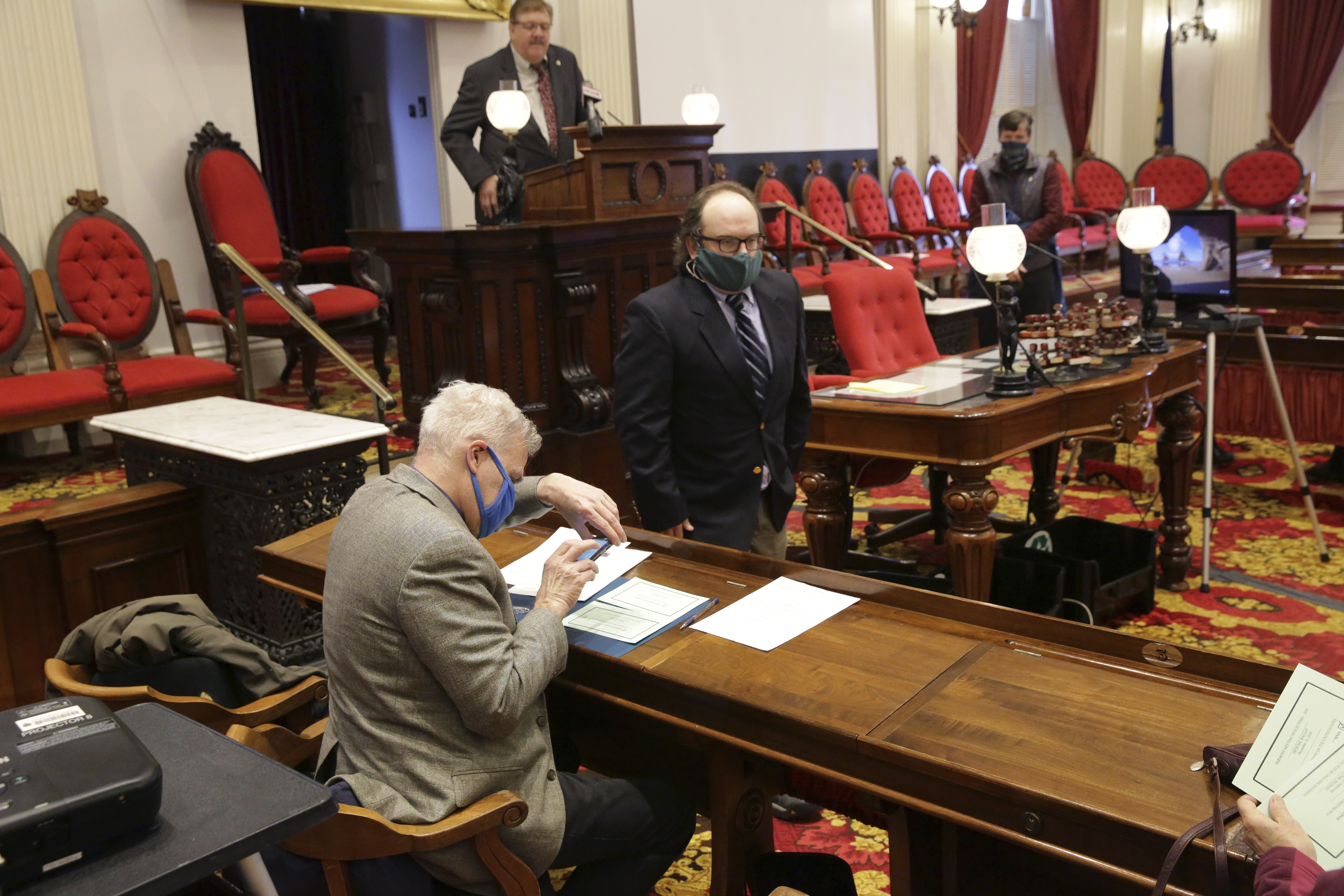Terje Anderson, left, one of the three members of Vermont's Electoral College, cast his vote at the Statehouse in Montpelier, Vt., on Monday.