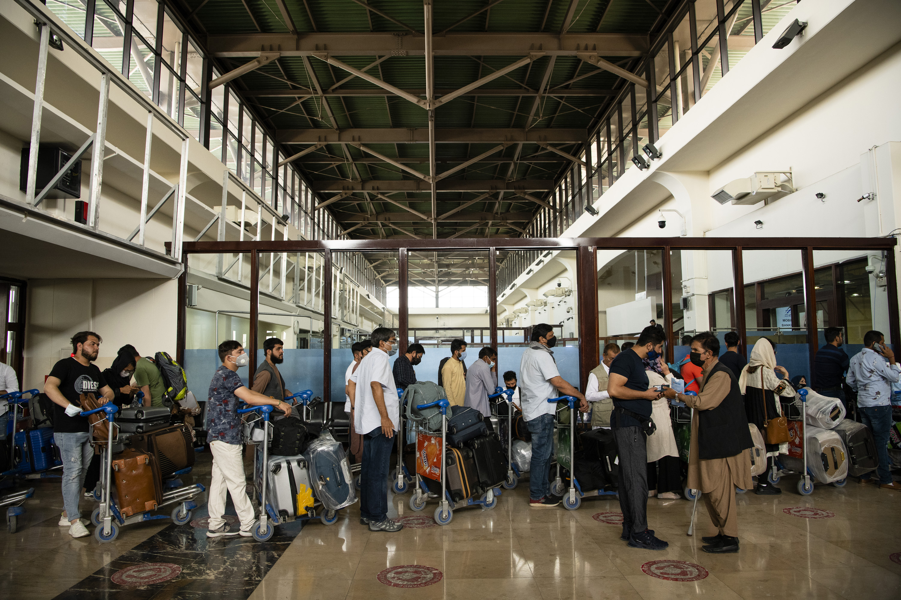 Afghans and travelers passed through checkpoints at the Hamid Karzai International Airport in Kabul, Afghanistan ahead of the Taliban's arrival, Aug. 15, 2021.