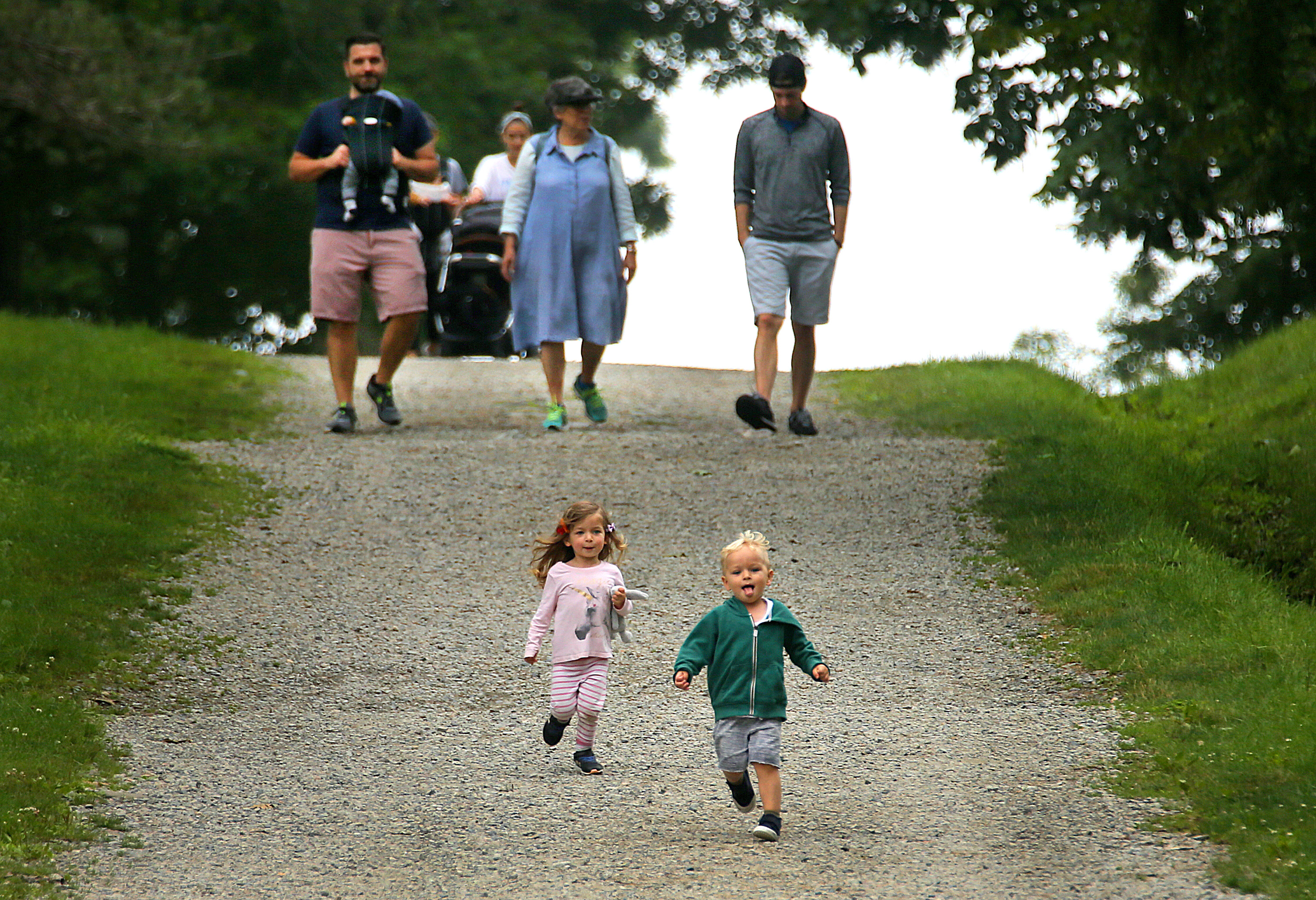 Maya Allen (left) and her cousin Max Wolff, both 2 1/2 from Montclair, N.J., run down a hill in front of their families. 