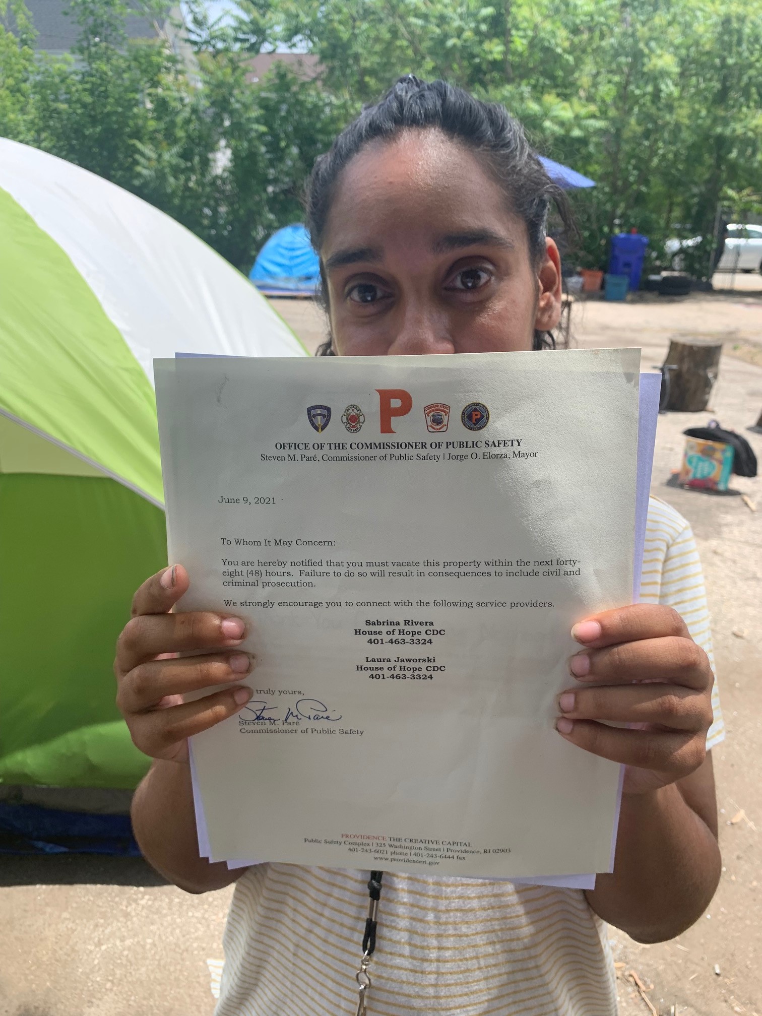 Diumila "Matilda" Almonte holds up notice from Providence officials telling people to leave vacant lot in city's West End within 48 hours.