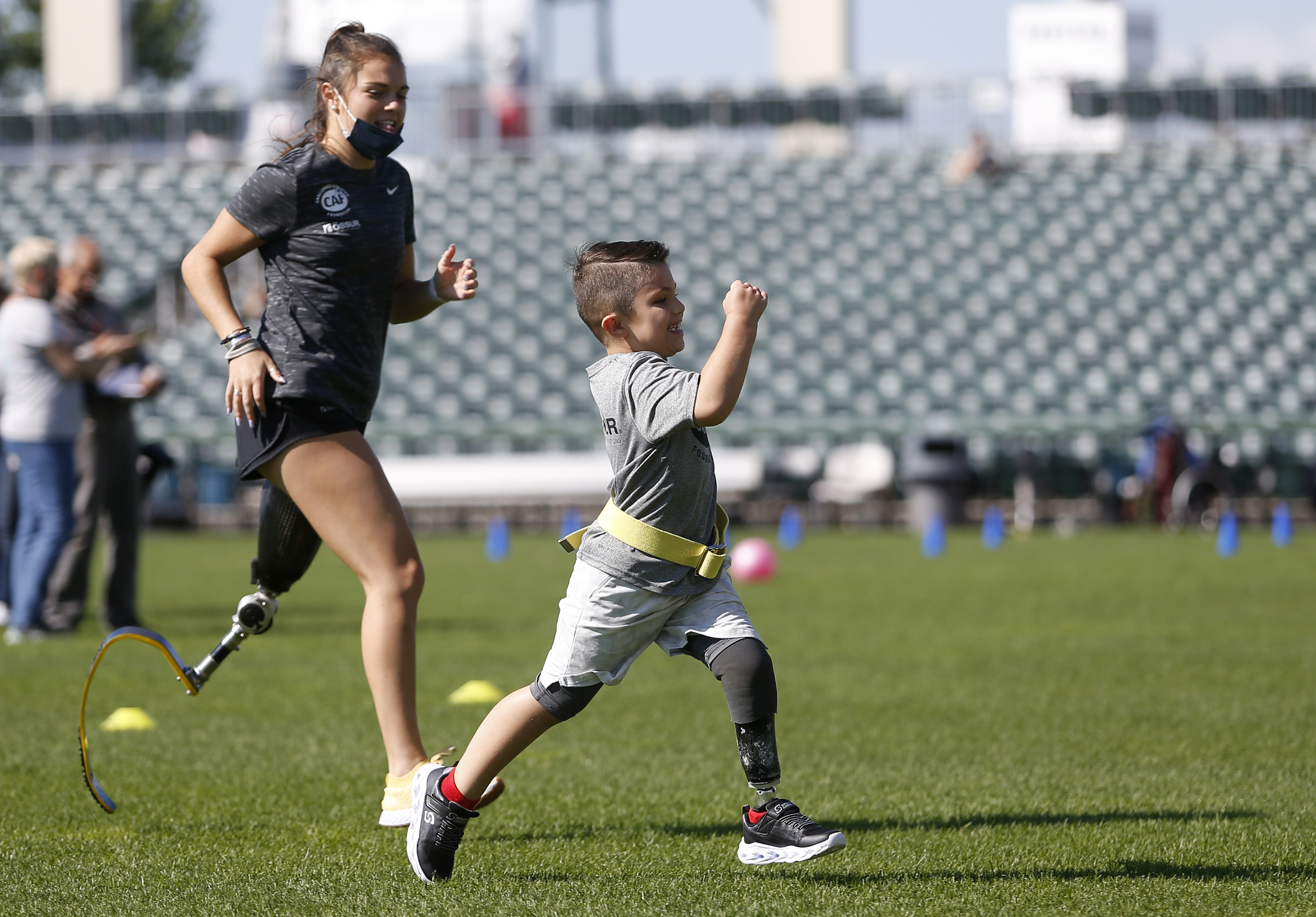 Isaak Depelteau, 6 (right) of Concord, NH, runs Paralympic athlete Noelle Lambert at the Ã–ssur and Challenged Athletes Foundation running and mobility clinic on Sunday.