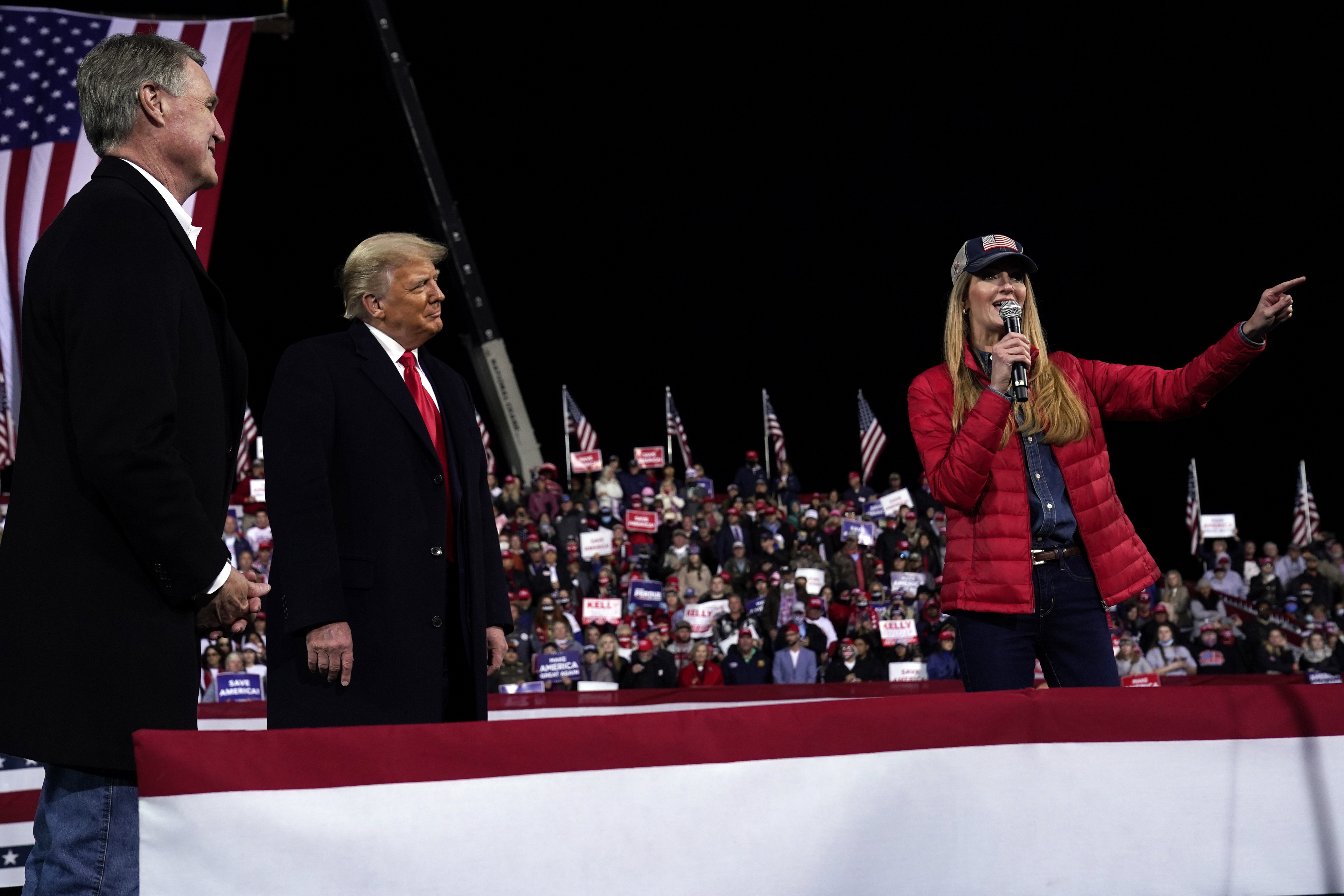 In this Dec. 5, 2020, photo, Senator Kelly Loeffler spoke as President Trump and Senator David Perdue listened at a campaign rally at Valdosta Regional Airport.