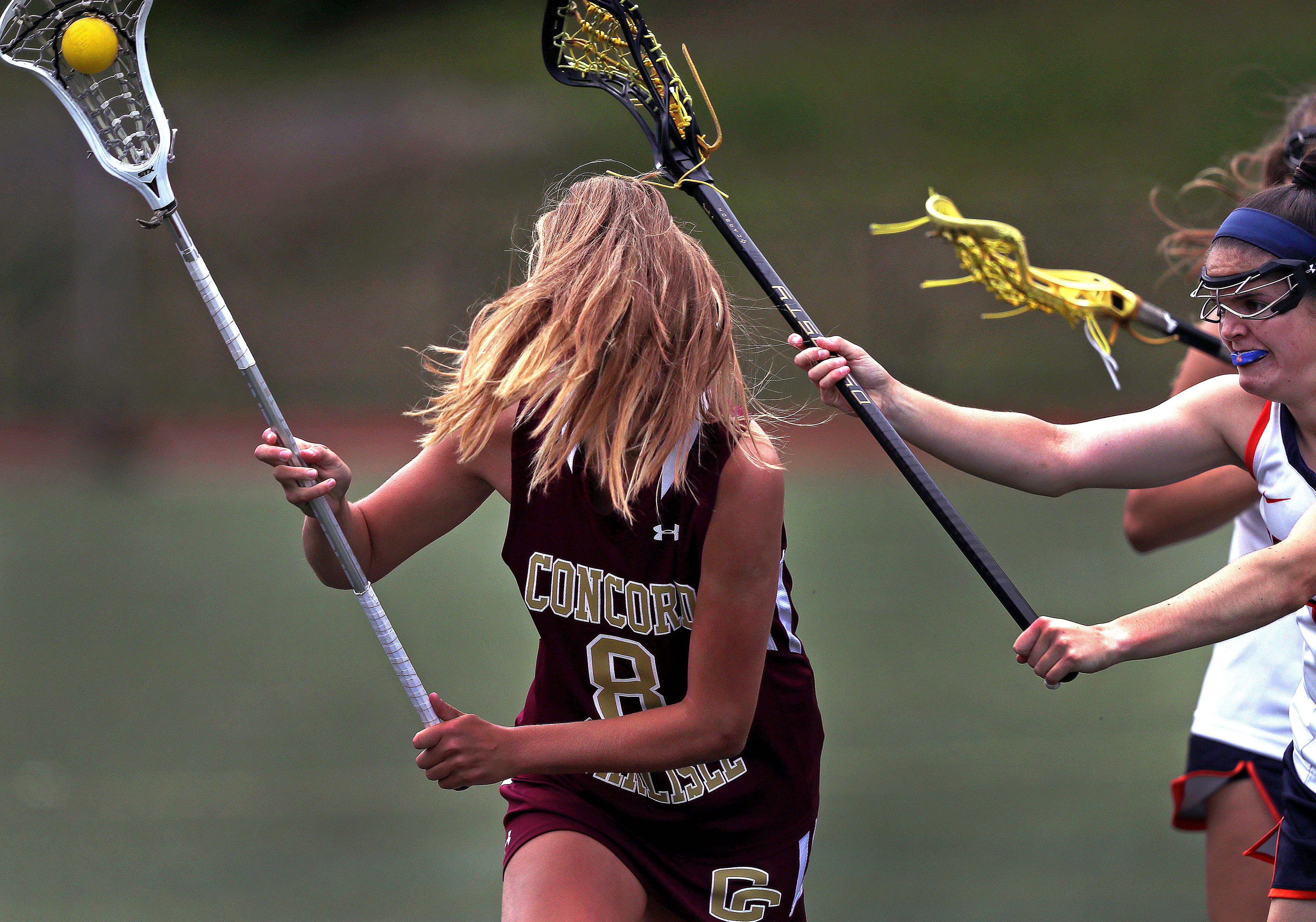 Concord-Carlisle’s Fallon Vaughn had a surprise obstacle (her hair) while carrying the ball during the Divison 1 East girls’ lacrosse final in Walpole on June 14. Walpole won the game, 11-9.