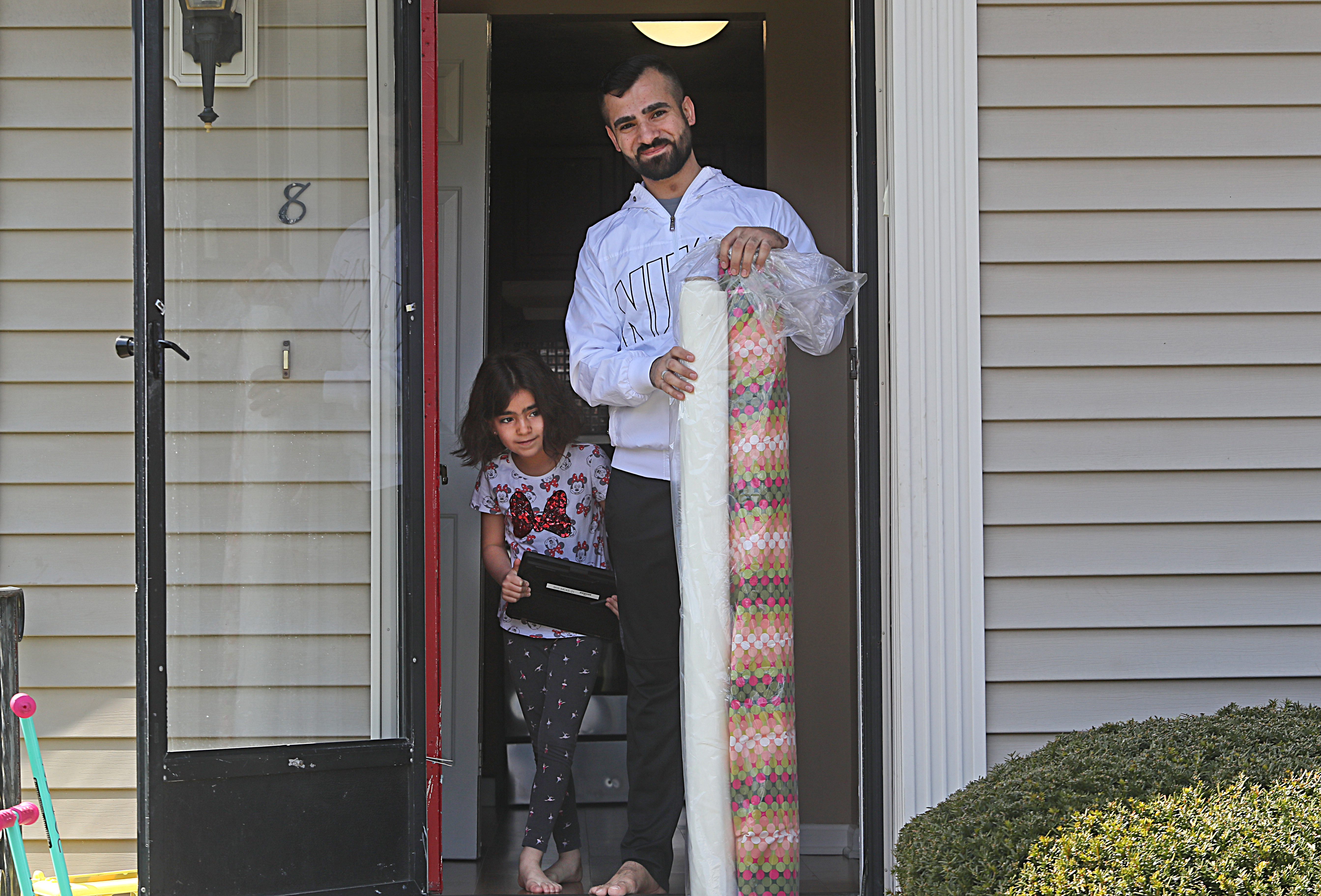 Adbulkader Hayani and daughter Fatimah, 7, received supplies to make masks from a member of Temple Beth Elohim.