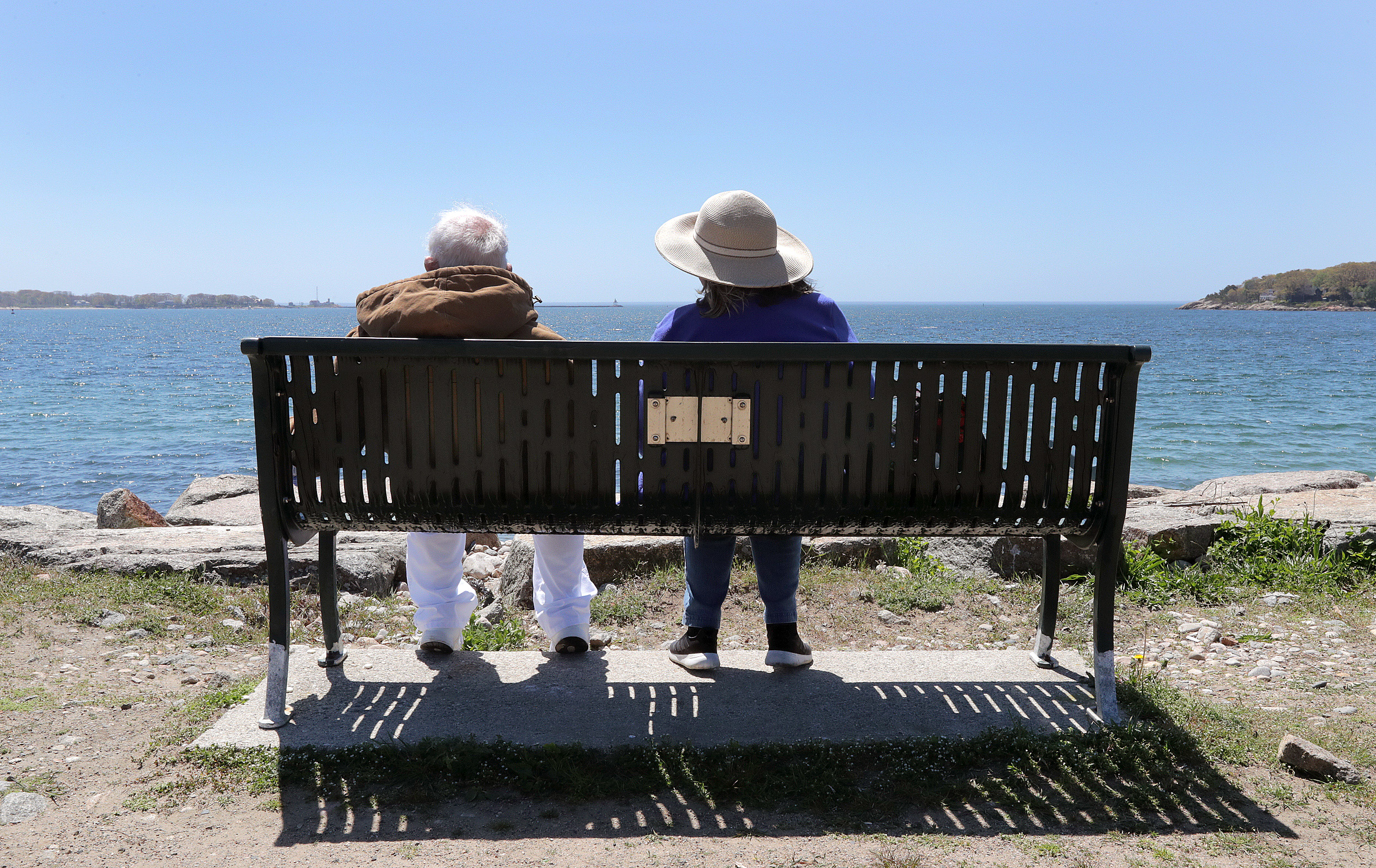 Visitors relaxed on a bench above the seawall at Stage Fort Park in Gloucester.