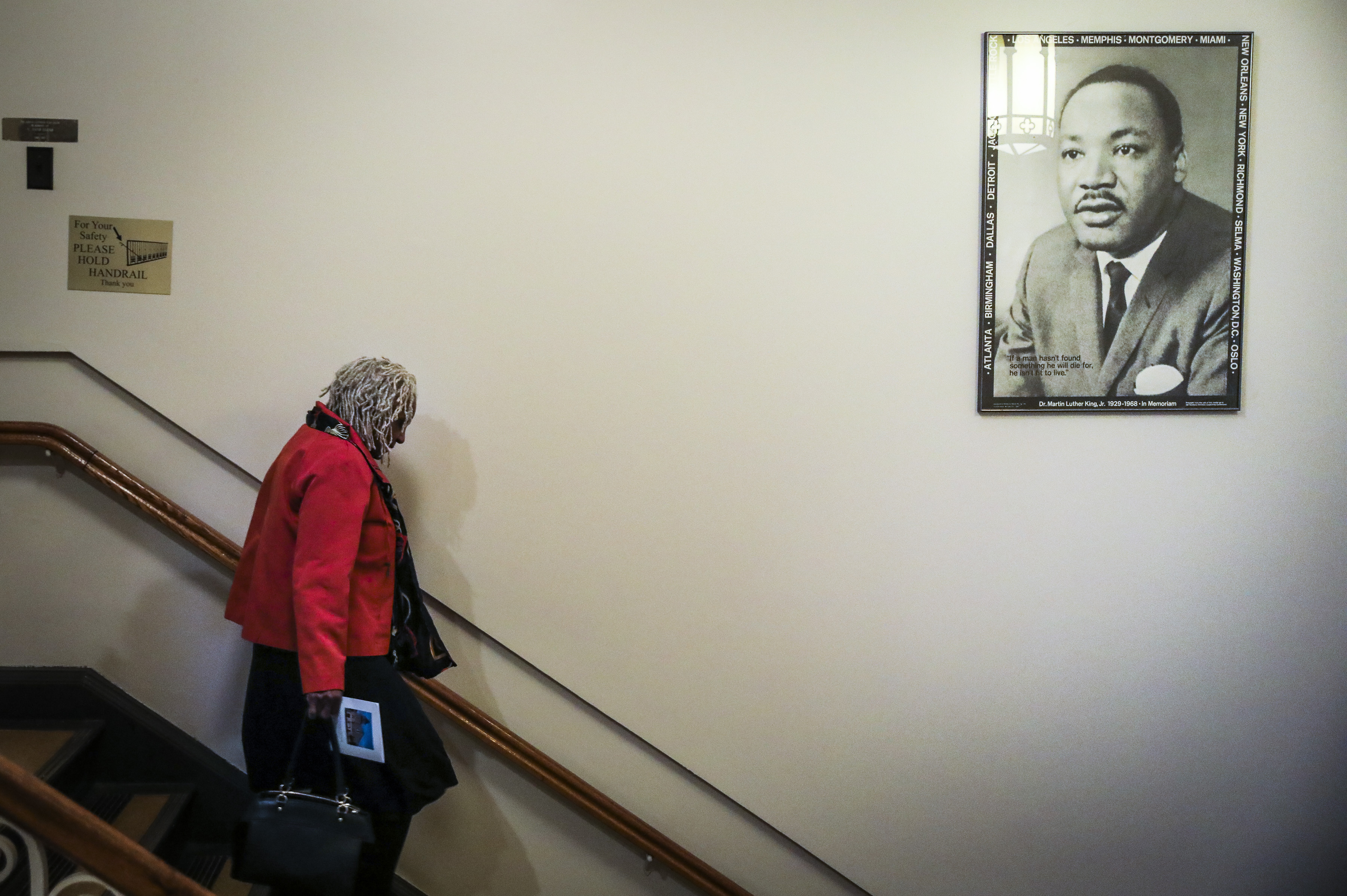 A woman walked past a portrait of Martin Luther King Jr. at the conclusion of the Martin Luther King Jr. Convocation at Roxbury’s Twelfth Baptist Church on January 12.