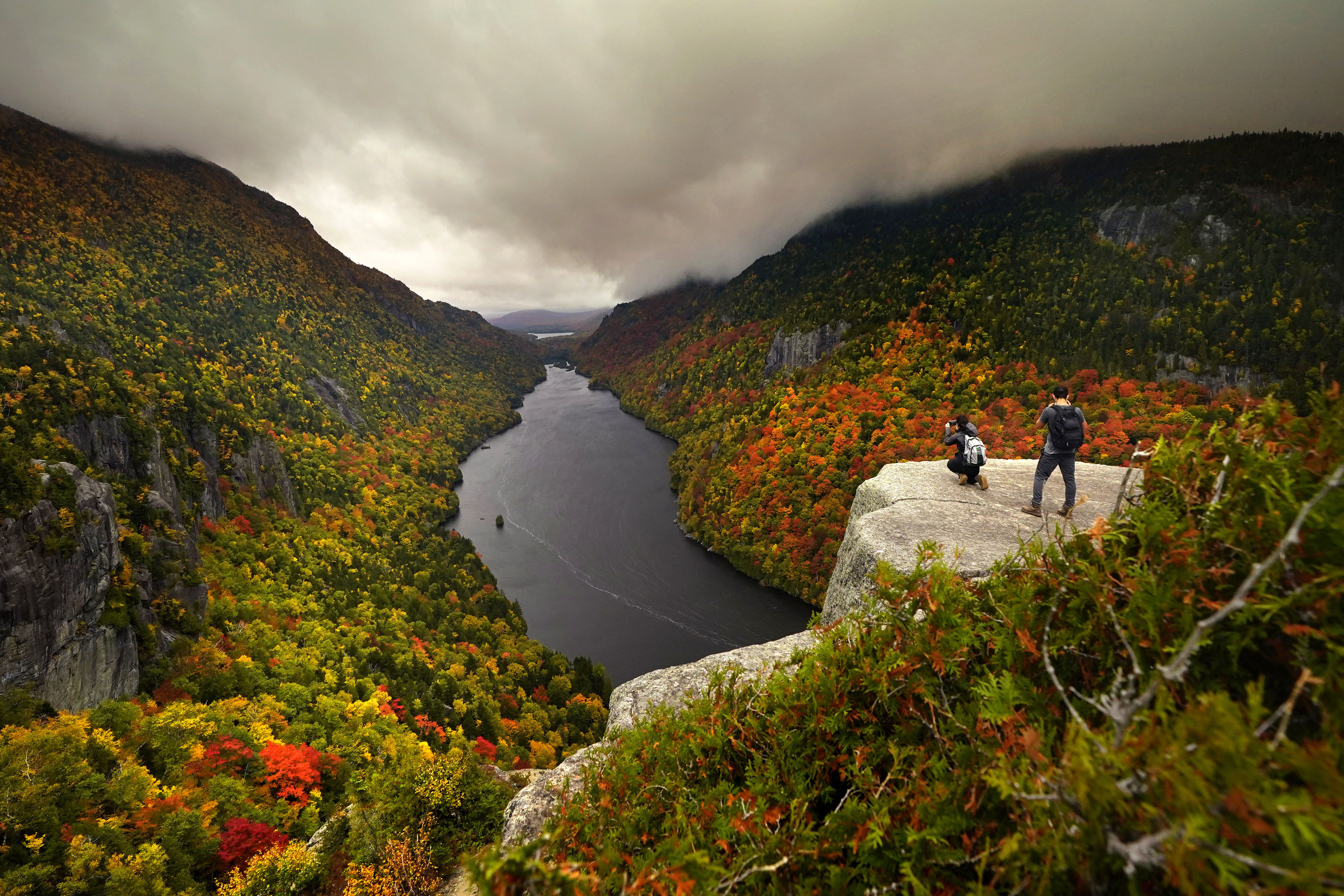 Two visitors photograph Lower Ausable Lake in the Adirondacks.