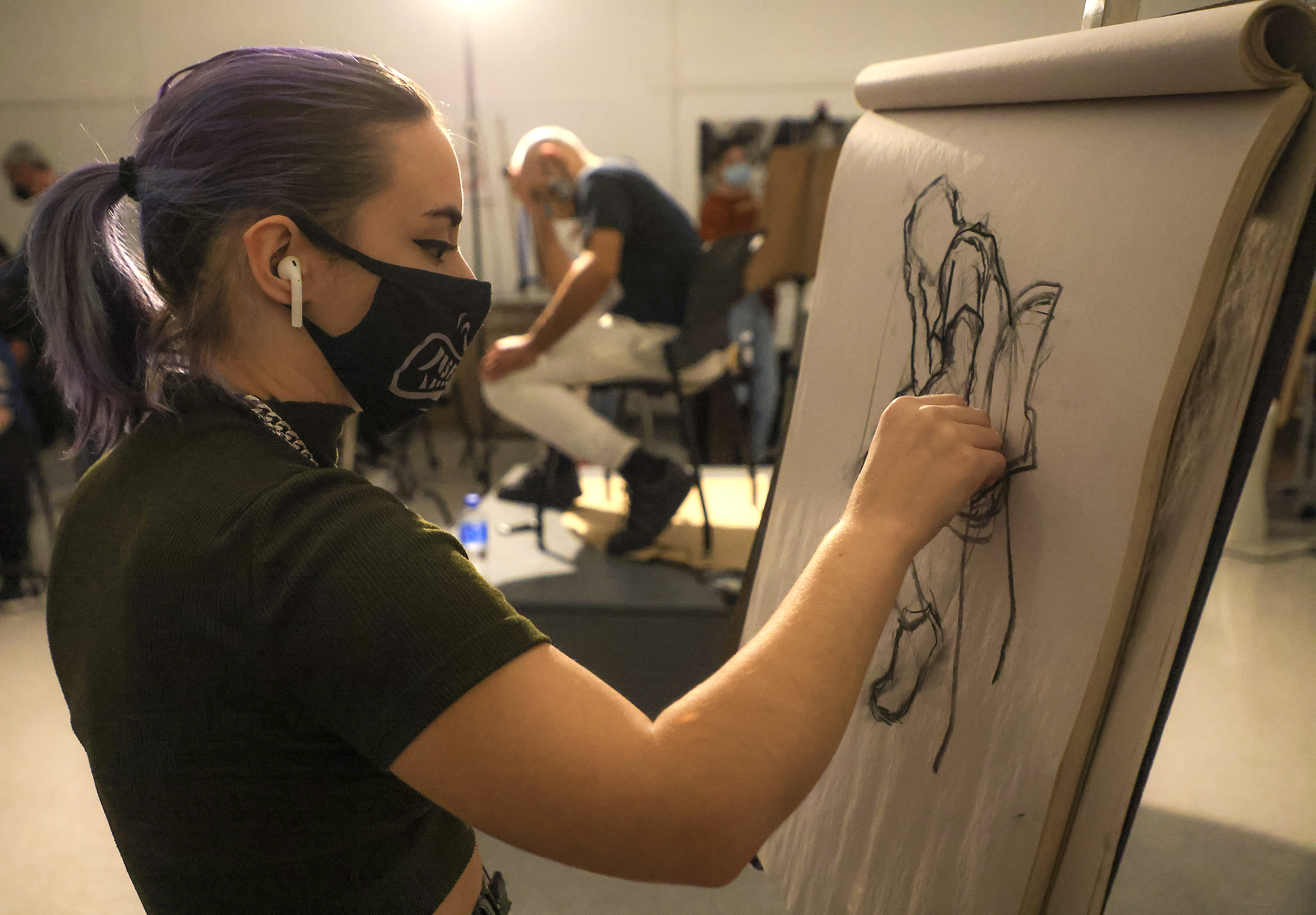 Josselyn Siegel, illustration student at MassArt, draws live model Ken Perez in her advanced drawing class.